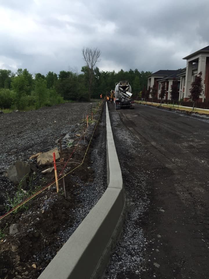 Une bordure en béton est en cours de construction au bord d'une route.