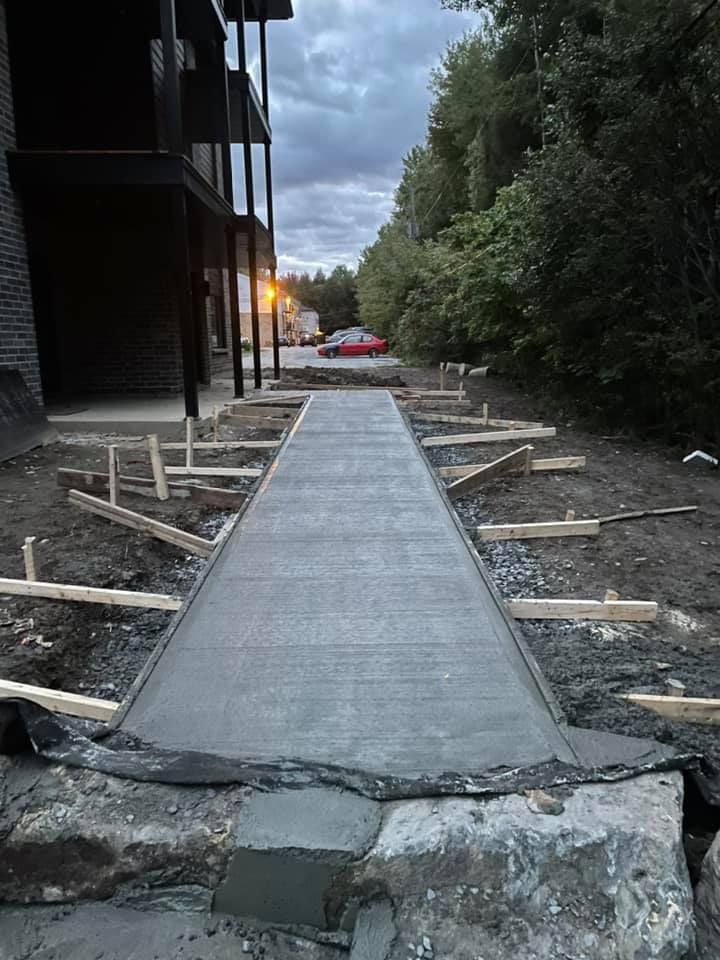 Une passerelle en béton est en cours de construction devant un immeuble.