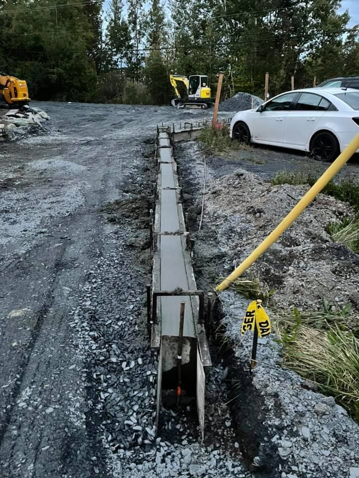 Une voiture blanche est garée dans un parking à côté d’un chantier de construction.