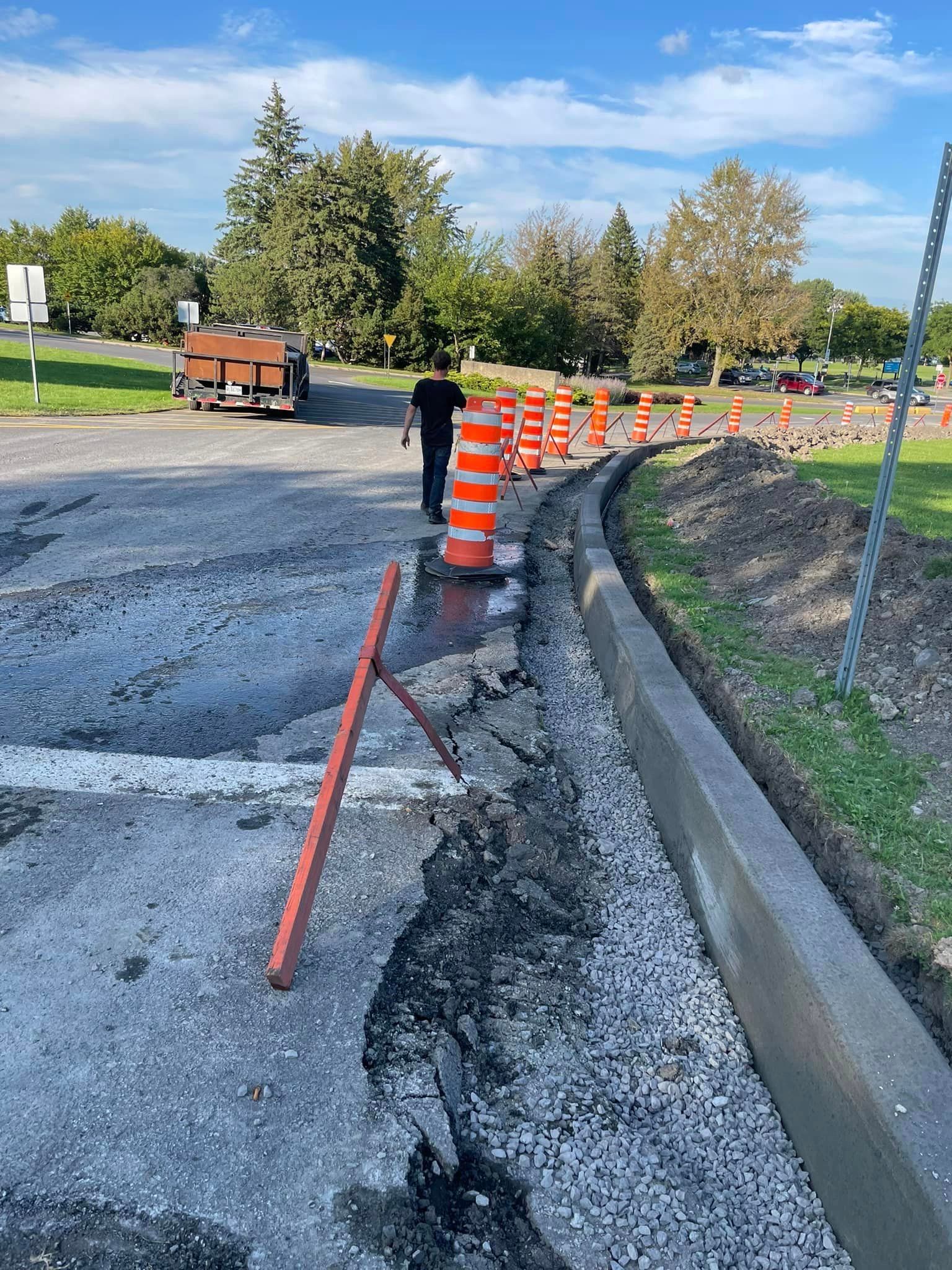 Un homme marche dans une rue à côté d’un chantier de construction.