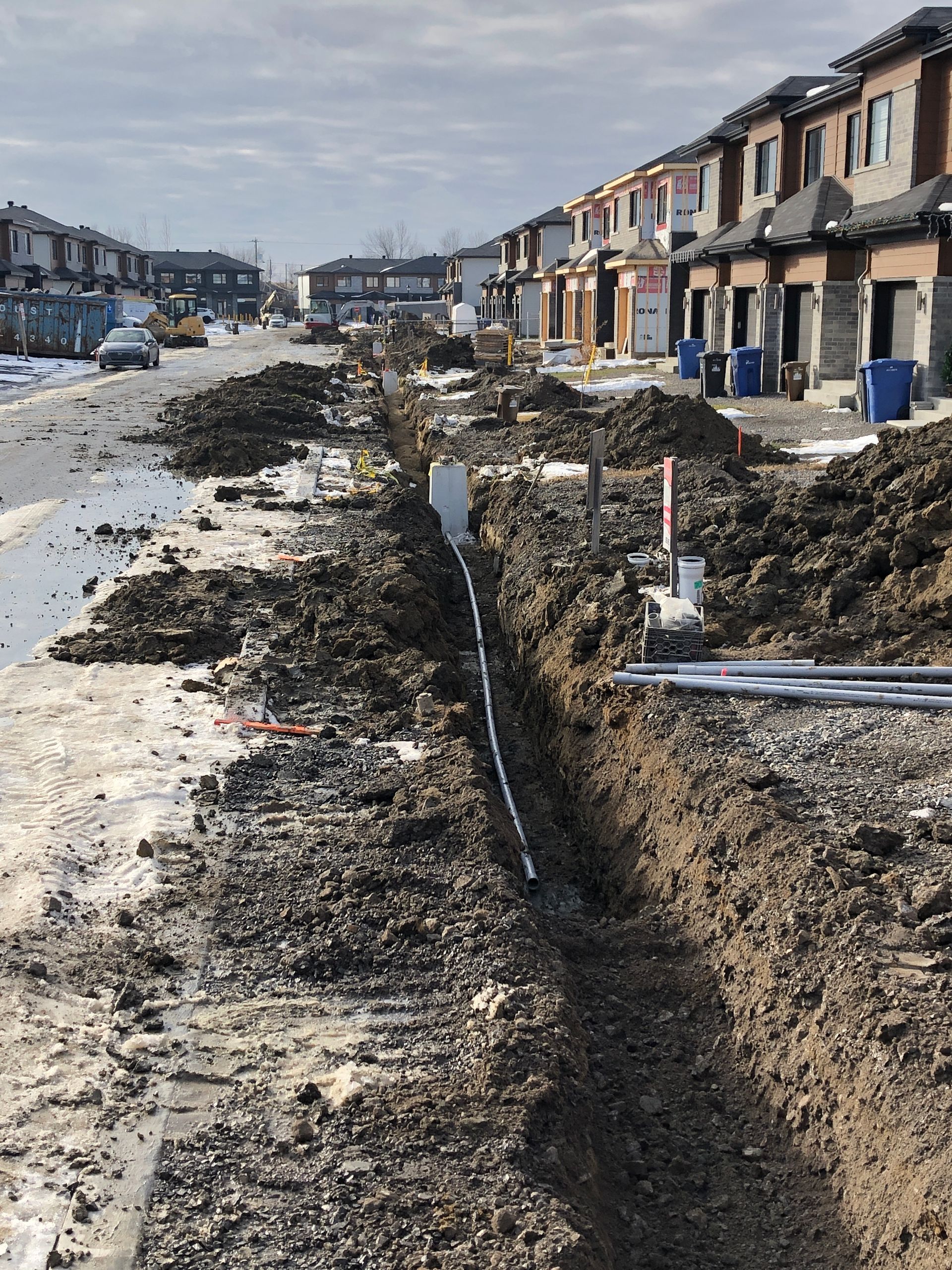 Une rangée de maisons est en construction sur un chemin de terre