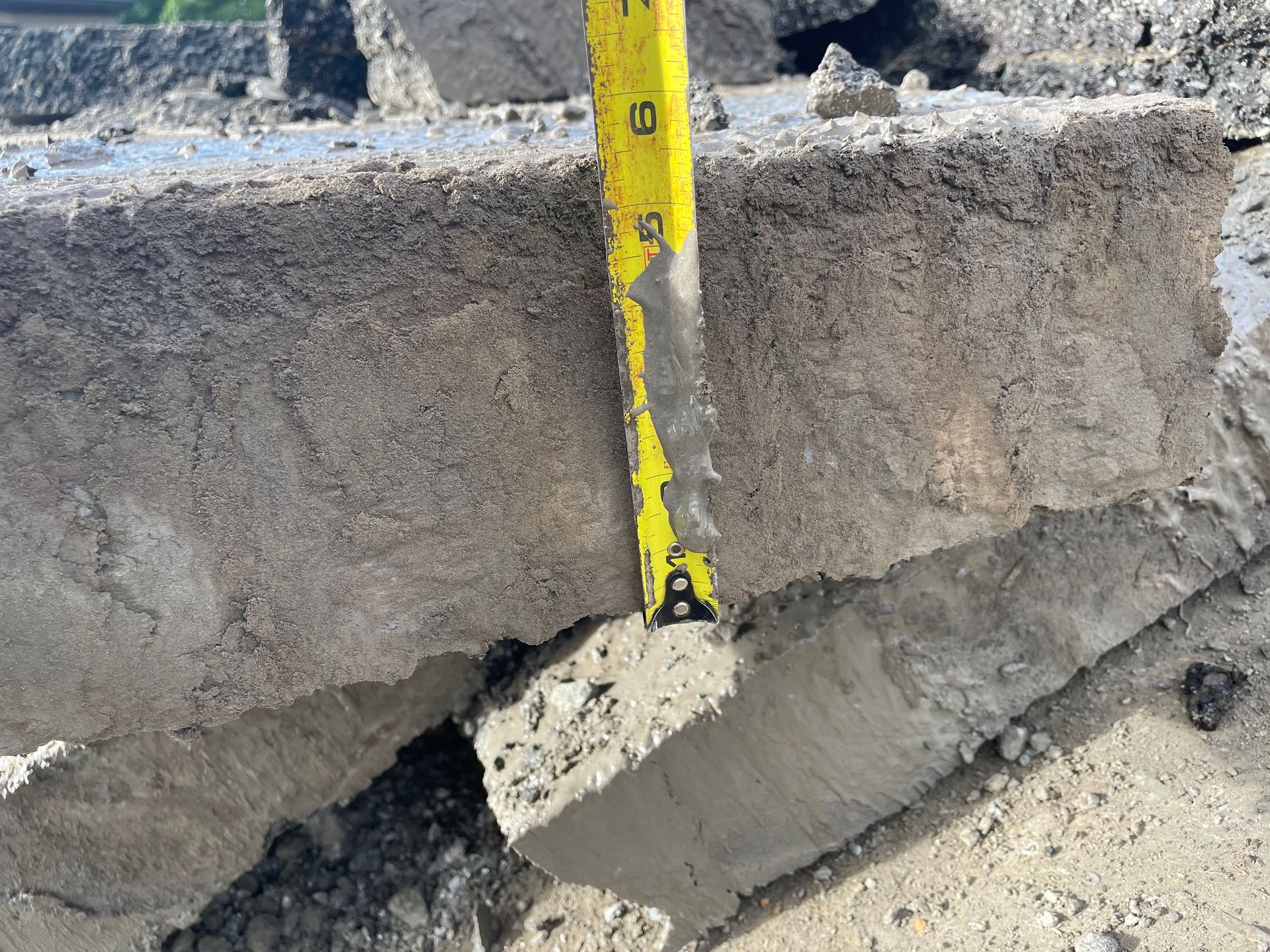 Un ruban à mesurer jaune mesure un morceau de béton.