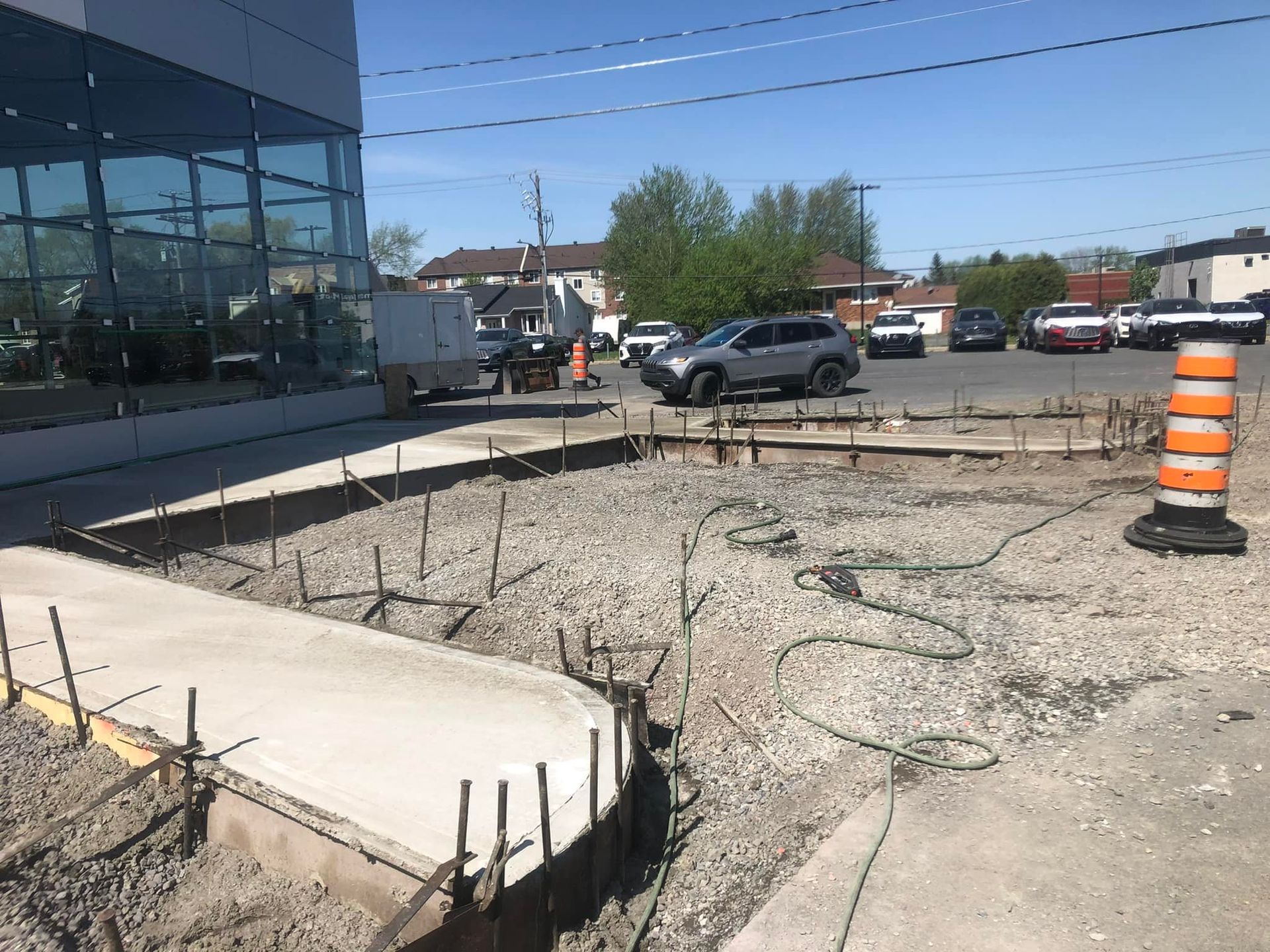 Une voiture est garée dans un parking à côté d’un chantier de construction.