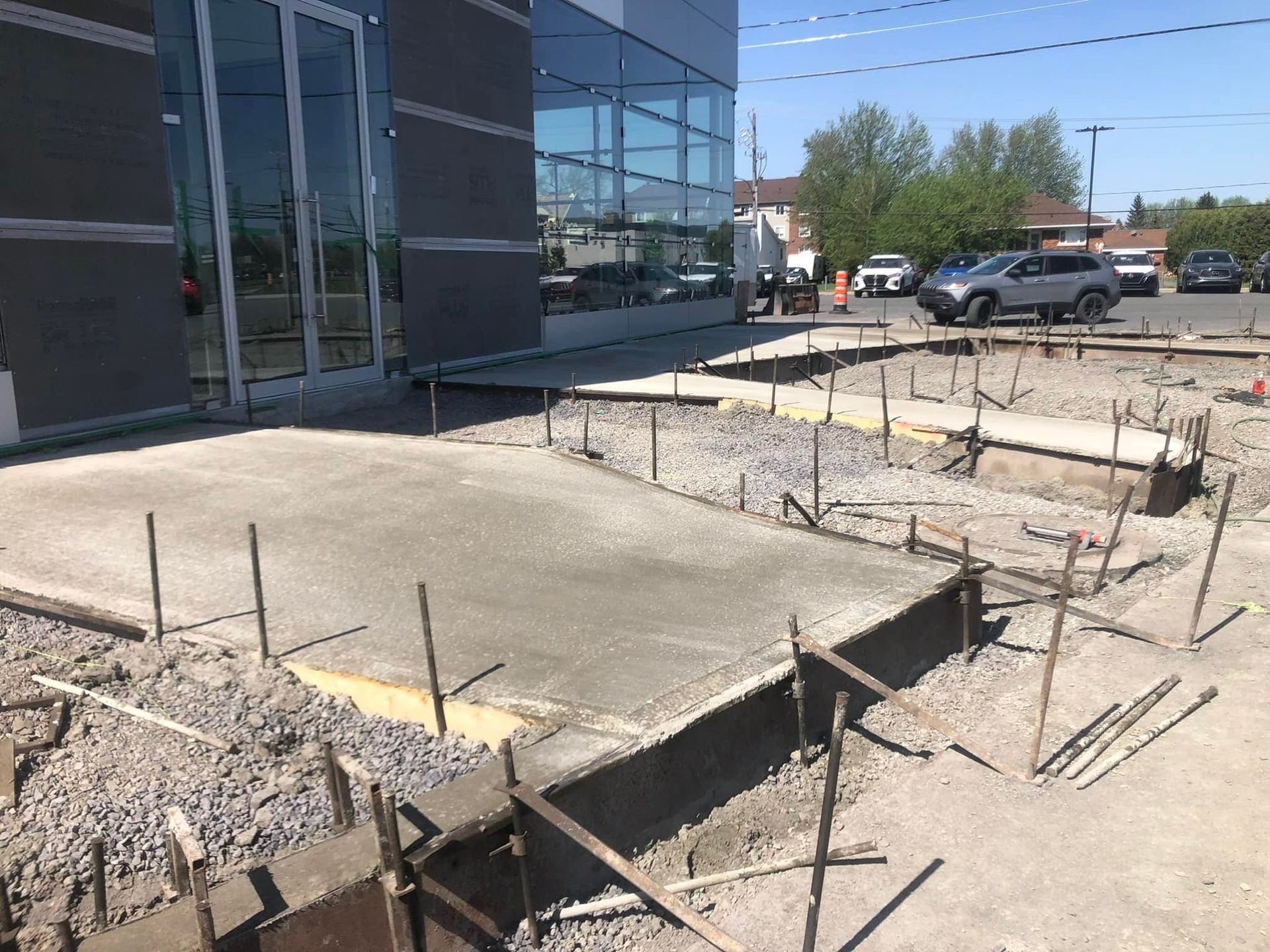Une passerelle en béton est en cours de construction devant un immeuble.