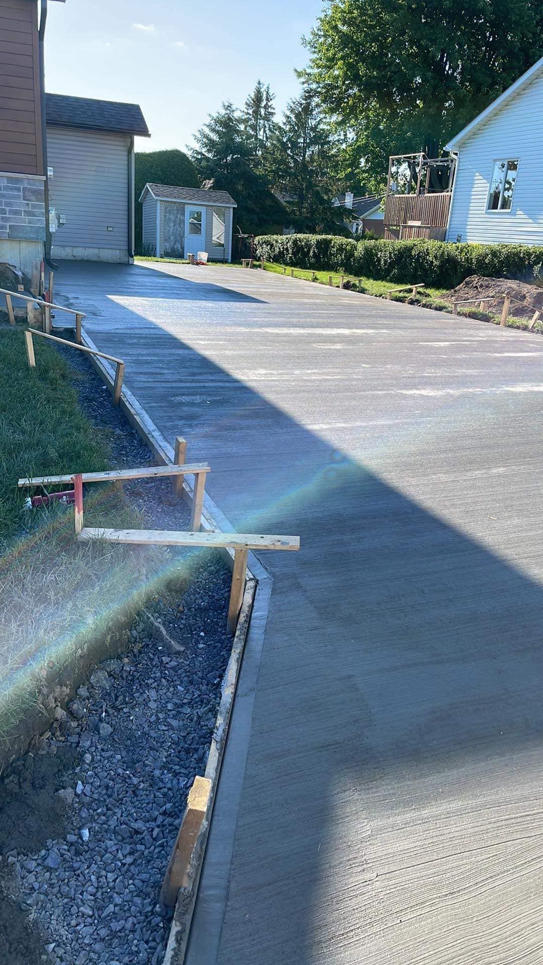 Une allée en béton est en cours de construction devant une maison.