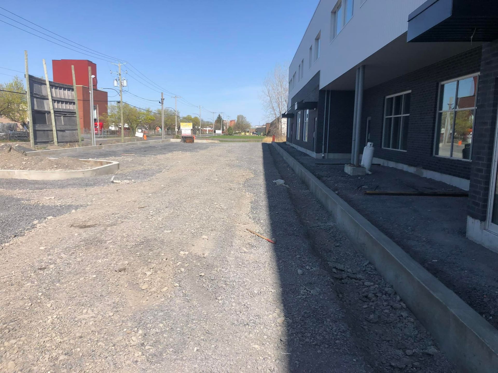 Un bâtiment est en construction à côté d'une route de gravier.