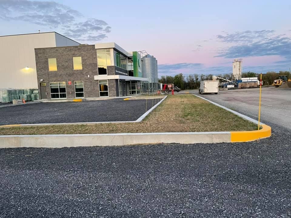 Un grand bâtiment avec un parking devant.