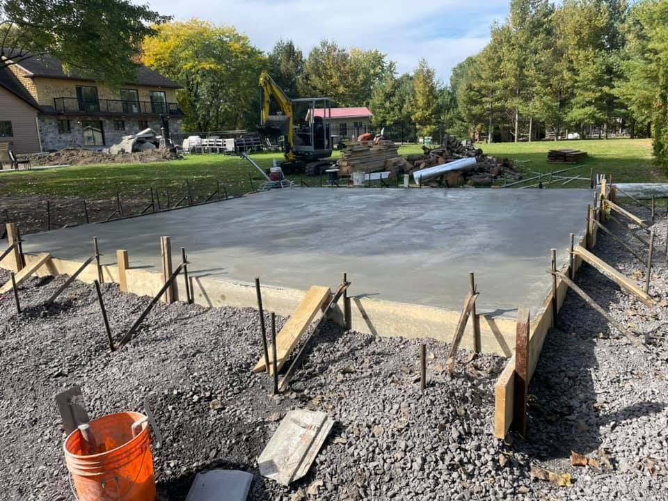 Une allée en béton est en cours de construction devant une maison.