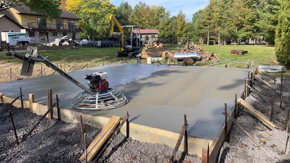 Un sol en béton est en cours de construction dans une cour.