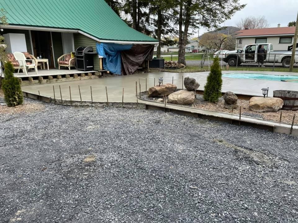 Une maison avec un toit vert est en cours de construction à côté d'une piscine.