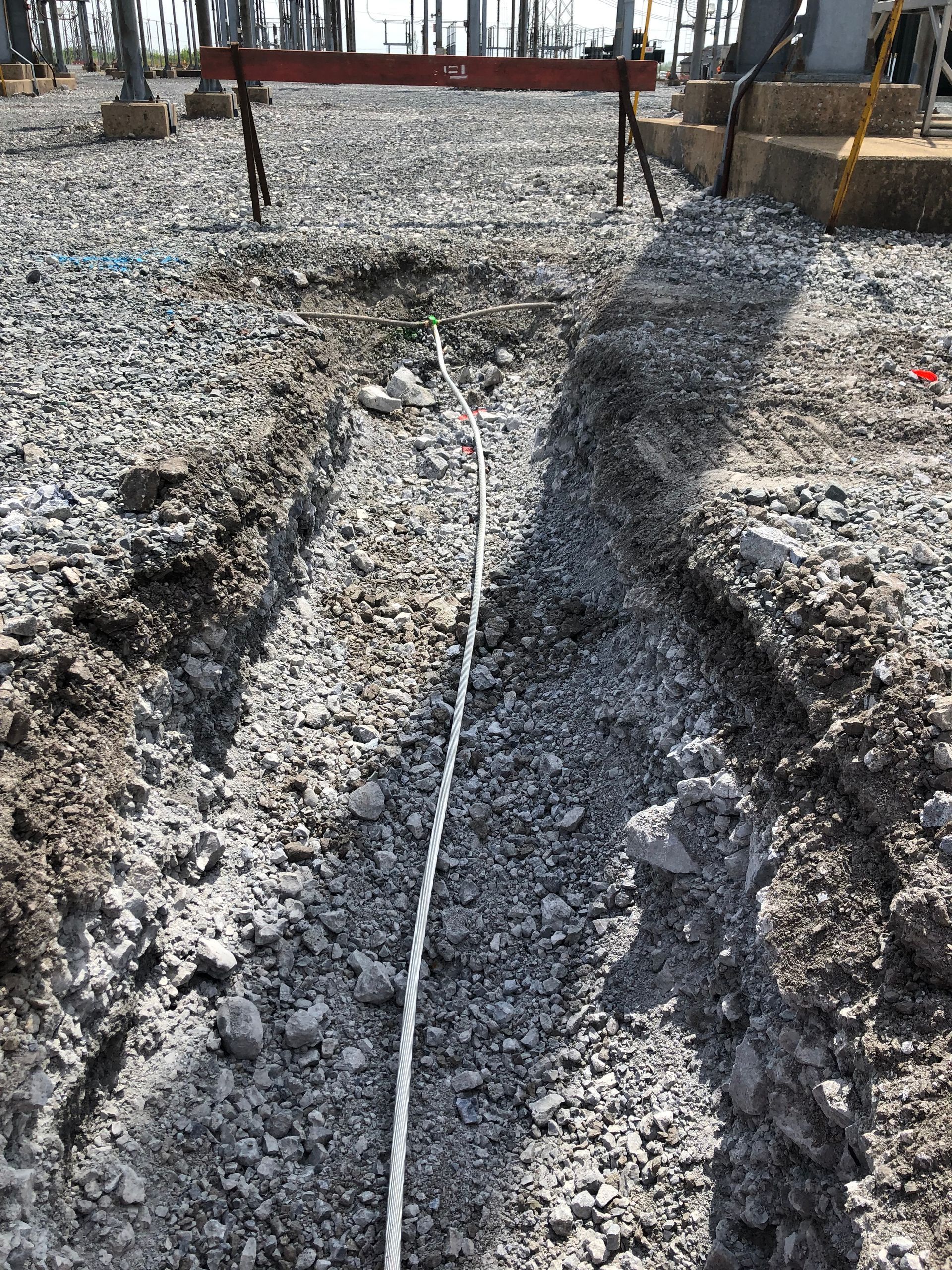 Une corde est posée dans la terre sur un chantier de construction.