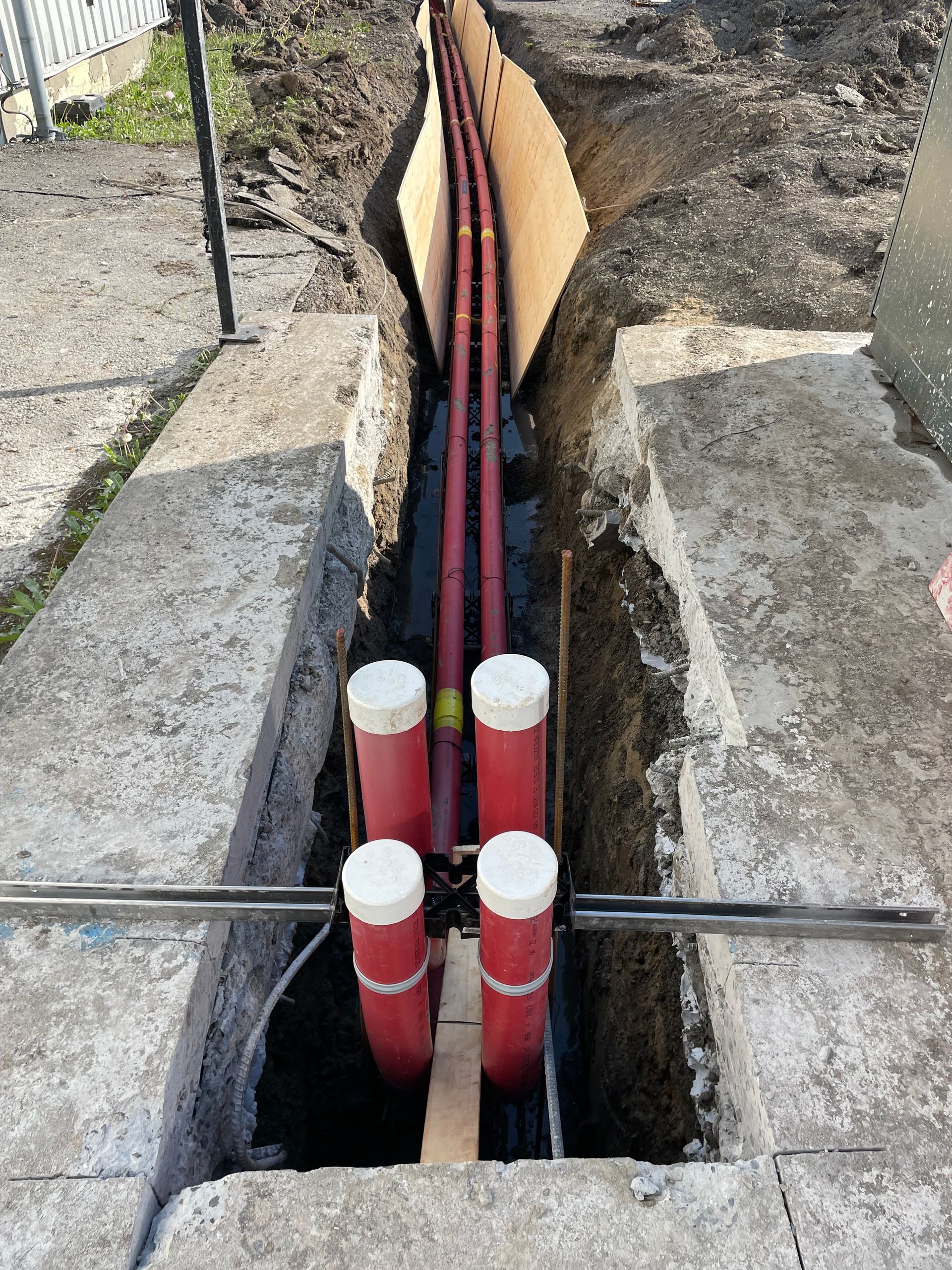 Un tas de tuyaux rouges se trouvent dans un trou dans le sol.