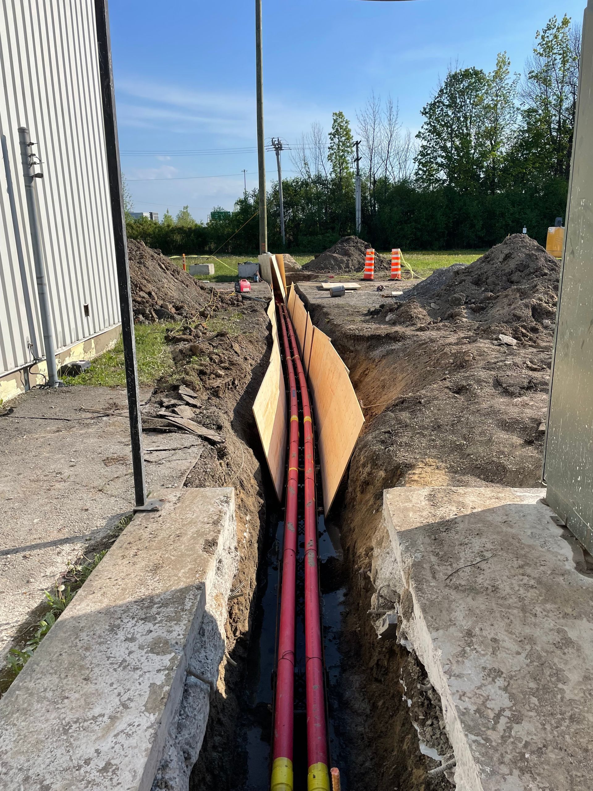 Un tas de tuyaux sont en cours d'installation dans une tranchée.