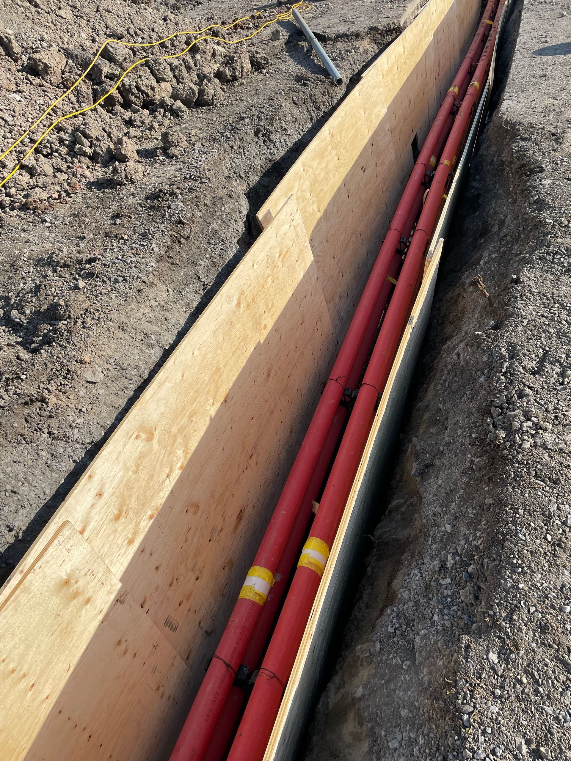 Un tas de tuyaux rouges sont dans une boîte en bois
