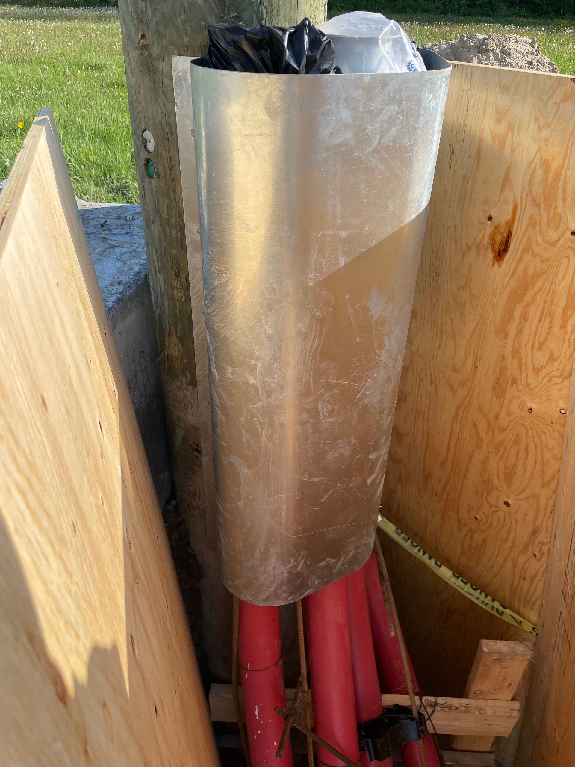 Une poubelle est posée sur une pile de planches de bois.