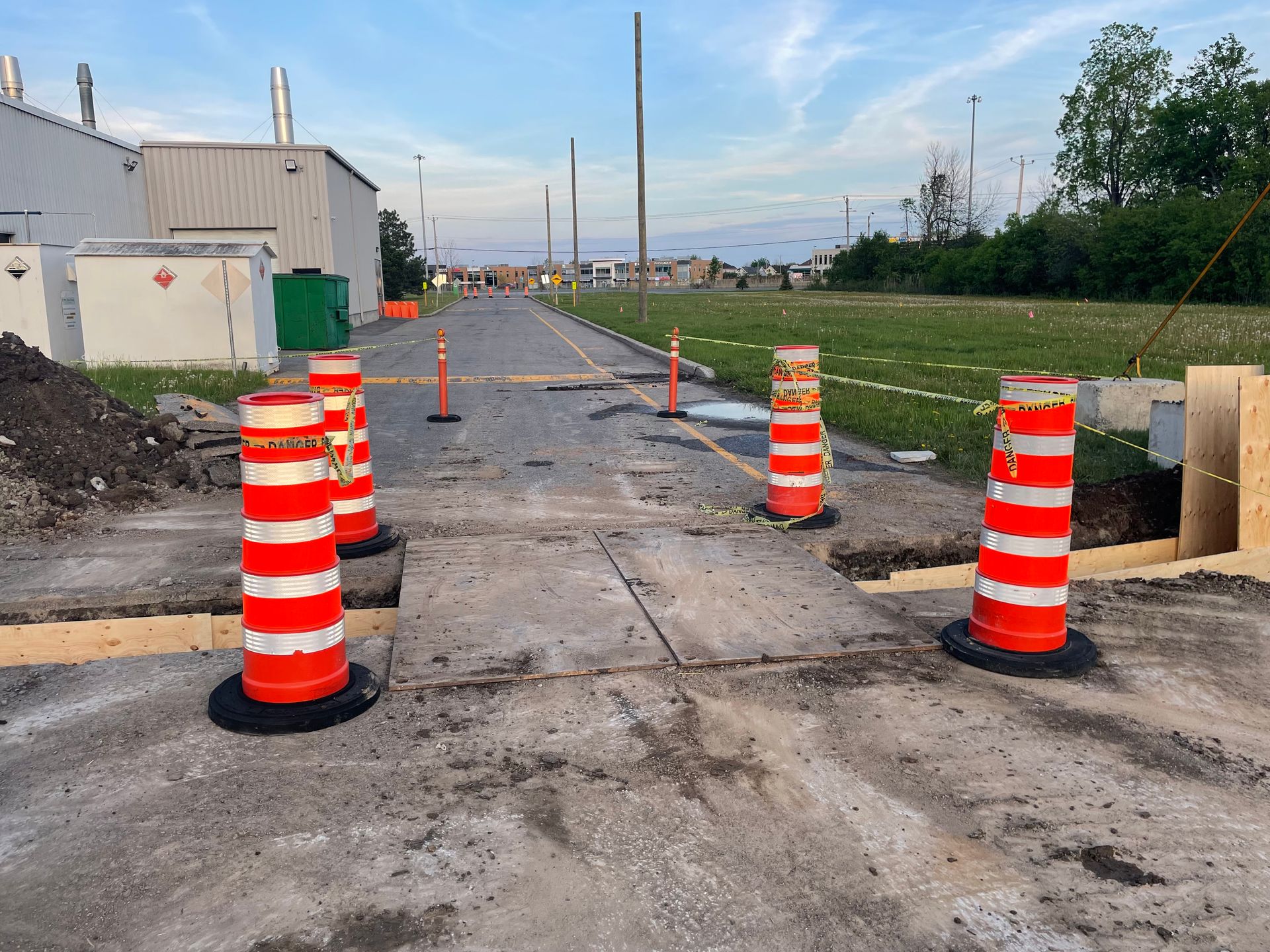 Une rangée de cônes de construction orange et blancs sur le bord d'une route