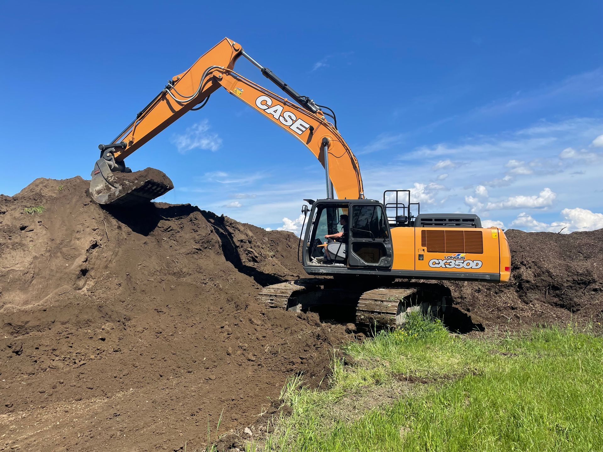 Une excavatrice creuse dans un tas de terre