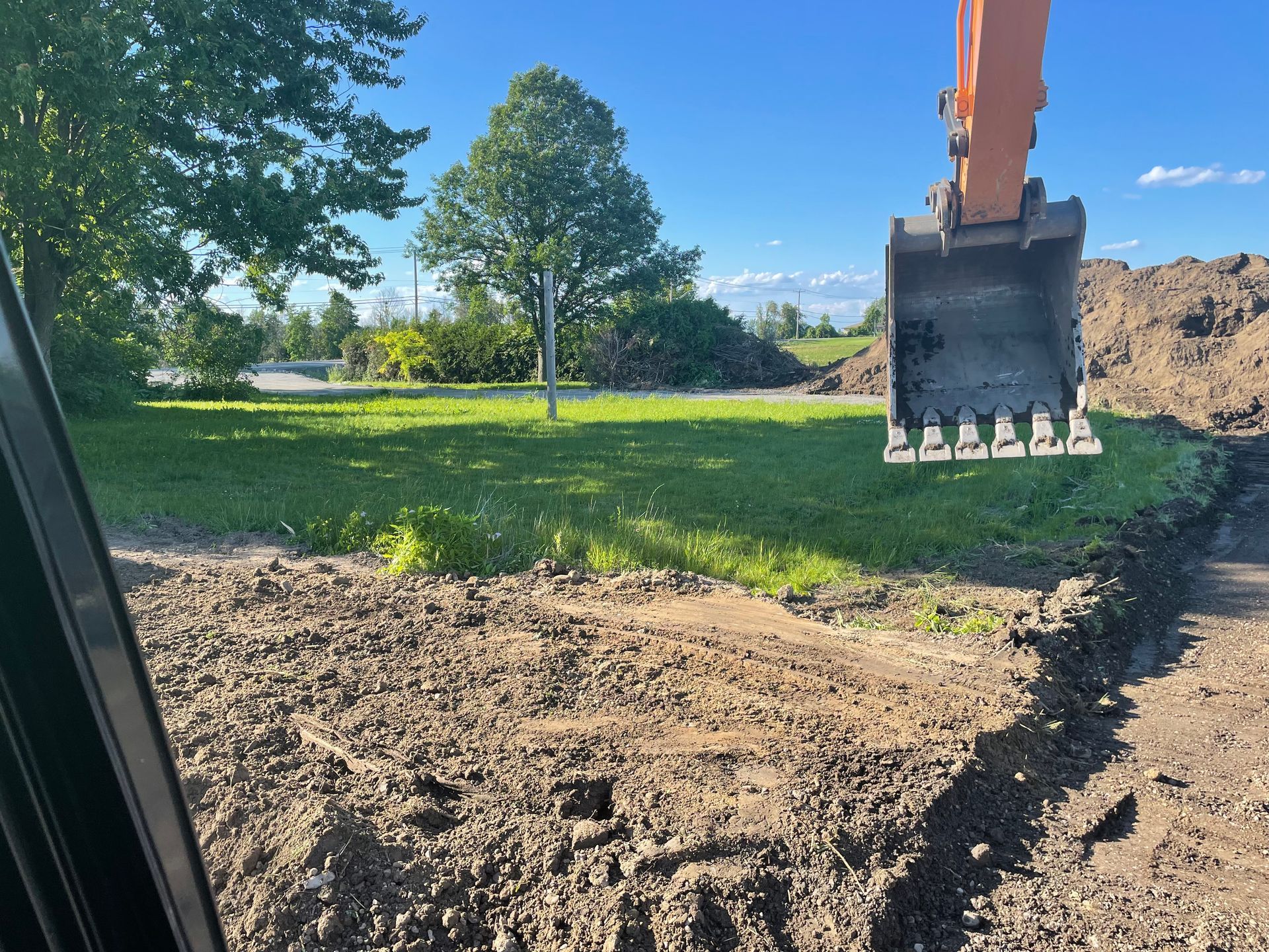 Une excavatrice creuse un trou dans le sol dans un champ.