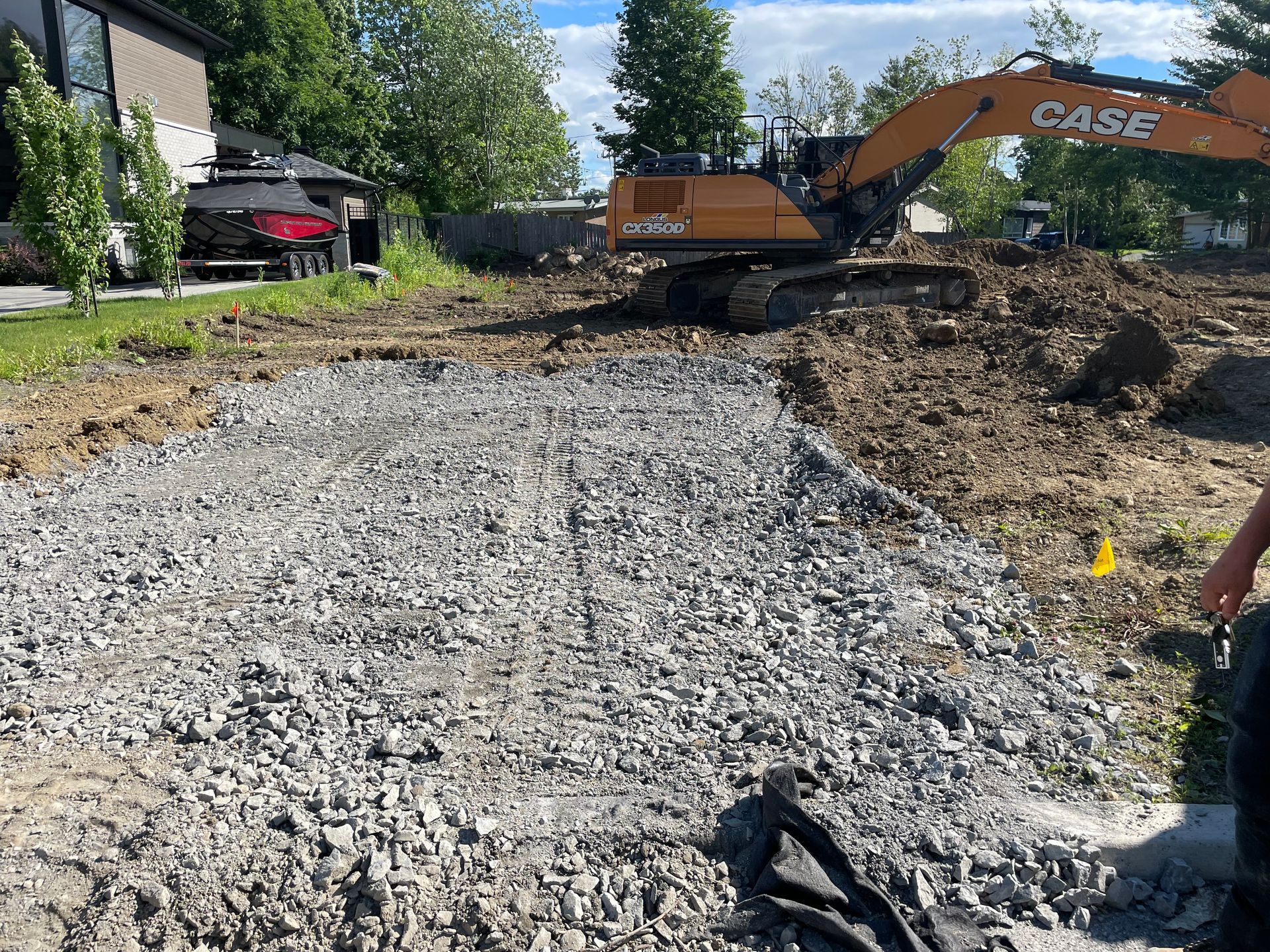 Une excavatrice de cas déplace du gravier sur un chantier de construction.