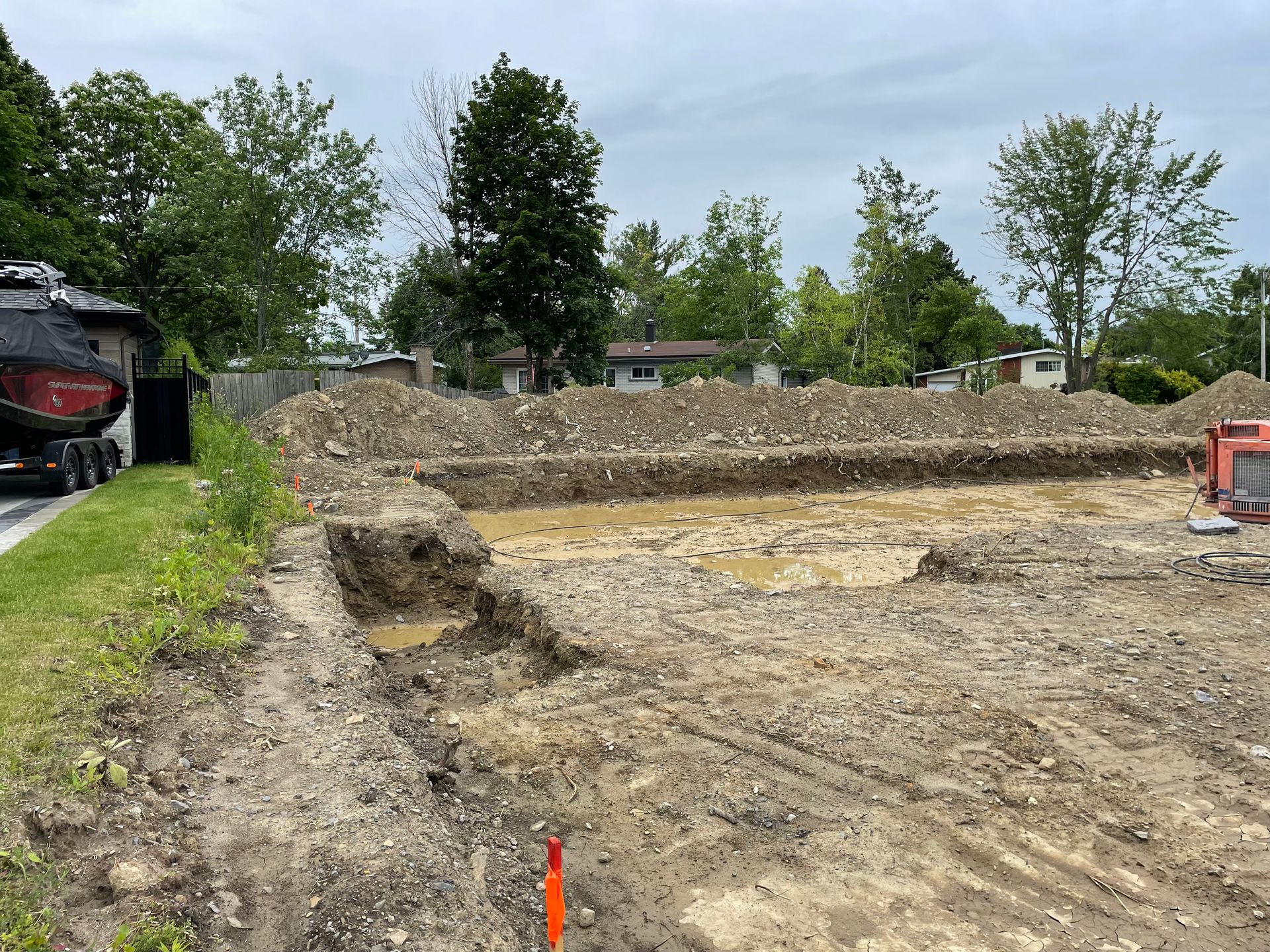 Un chantier de construction avec beaucoup de terre et des arbres en arrière-plan.