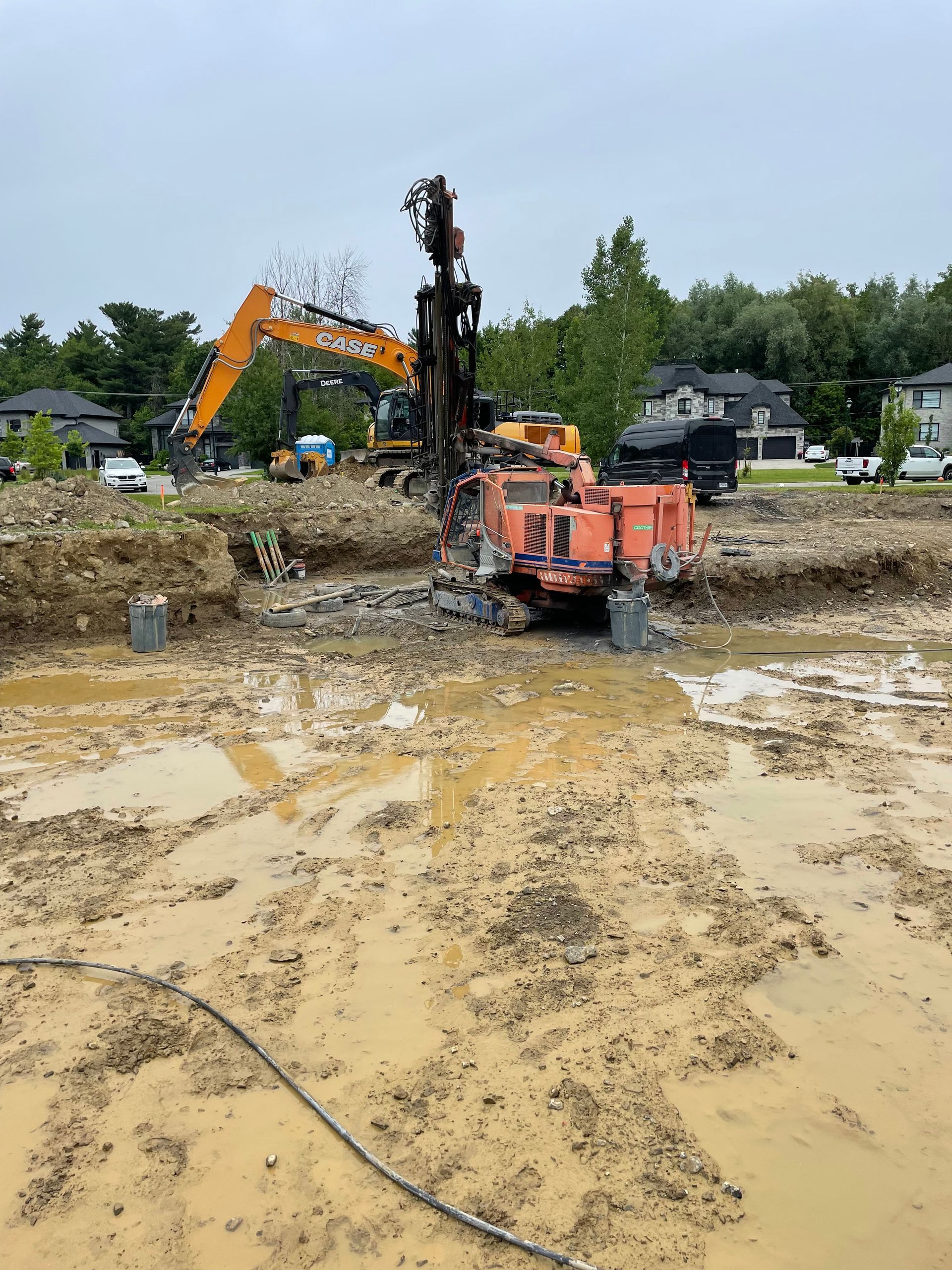 Un chantier de construction avec beaucoup de terre et une grosse pelle en arrière-plan.