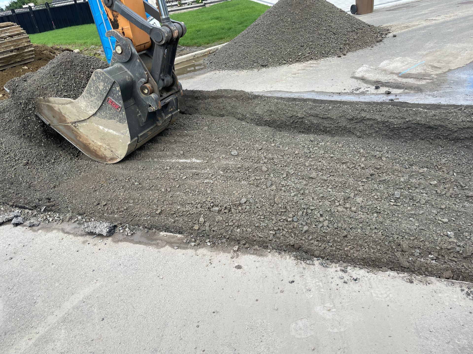 Un bulldozer déplace du gravier sur le bord d’une route.