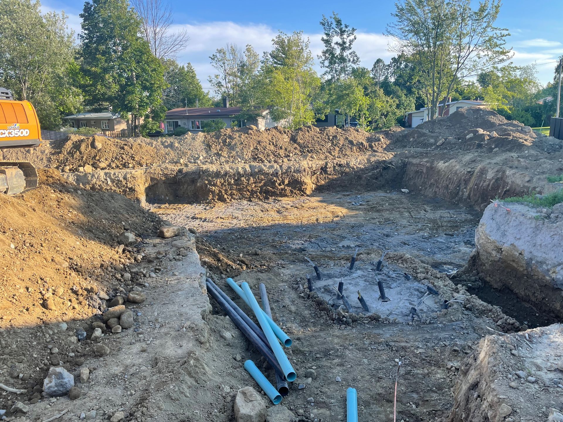 Un chantier de construction avec un bulldozer et des tuyaux dans la terre.