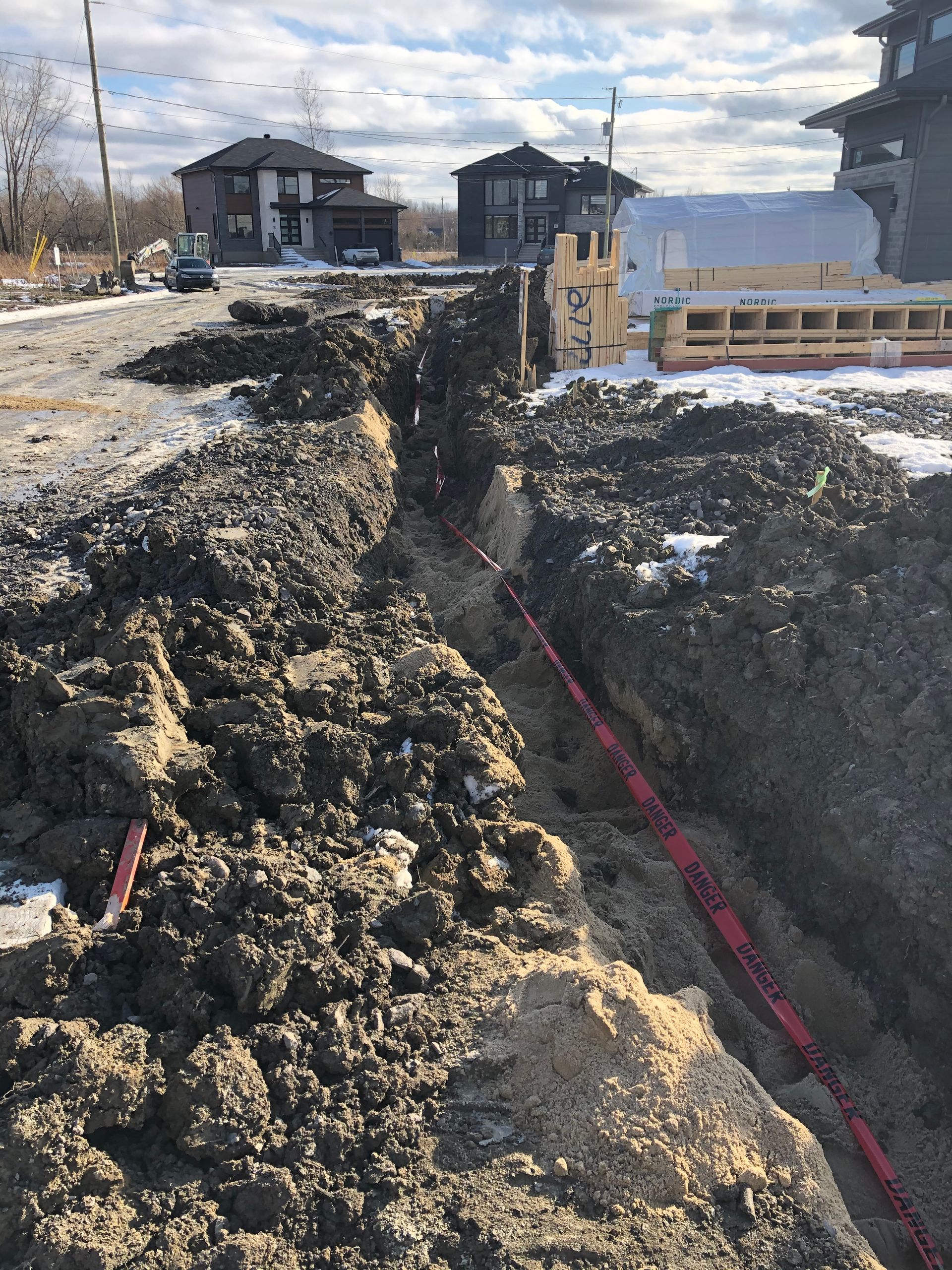 Un chantier de construction avec beaucoup de terre et des maisons en arrière-plan