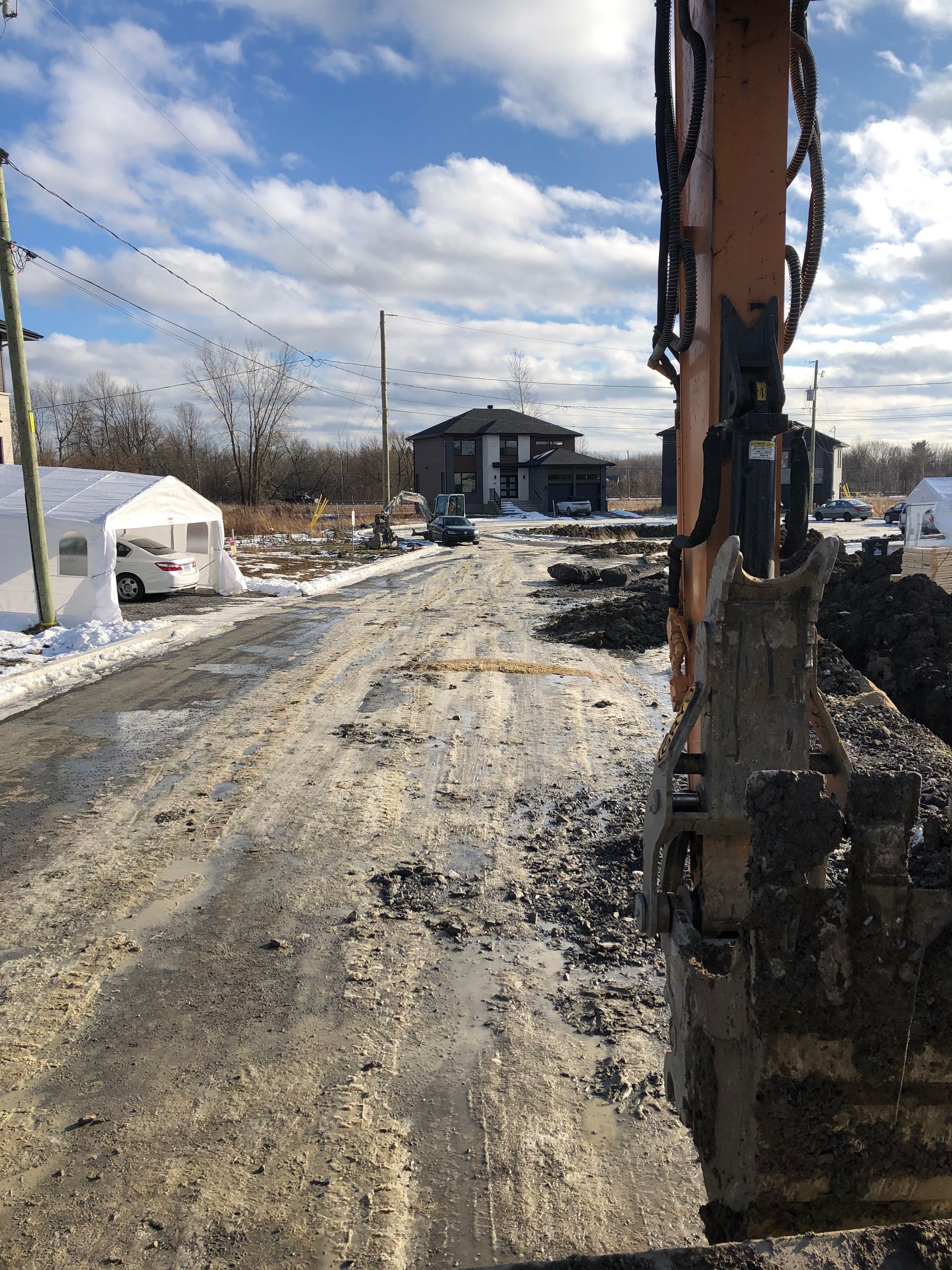 Un véhicule de construction roule sur un chemin de terre.