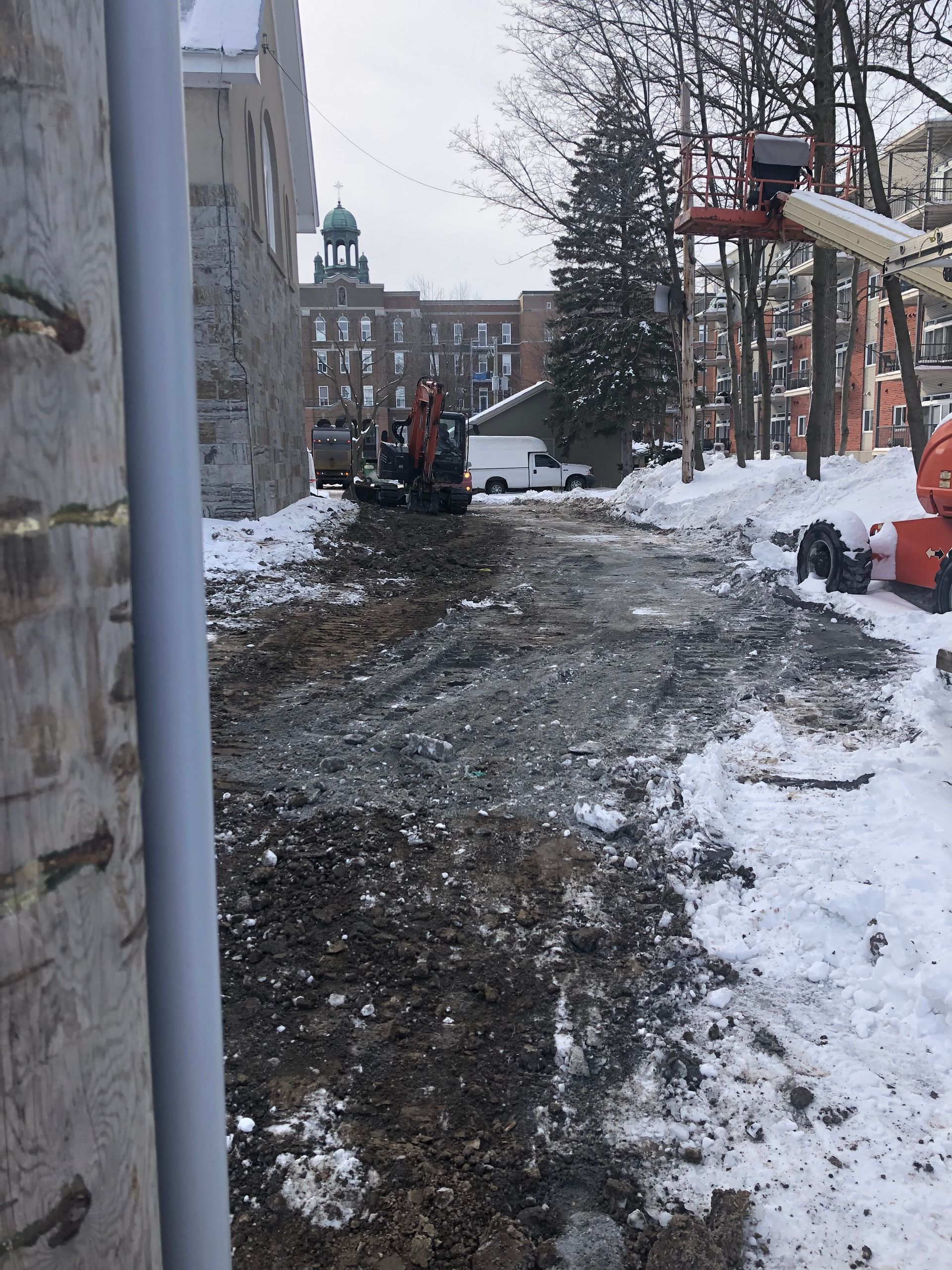 Une rue enneigée avec un bâtiment en arrière-plan