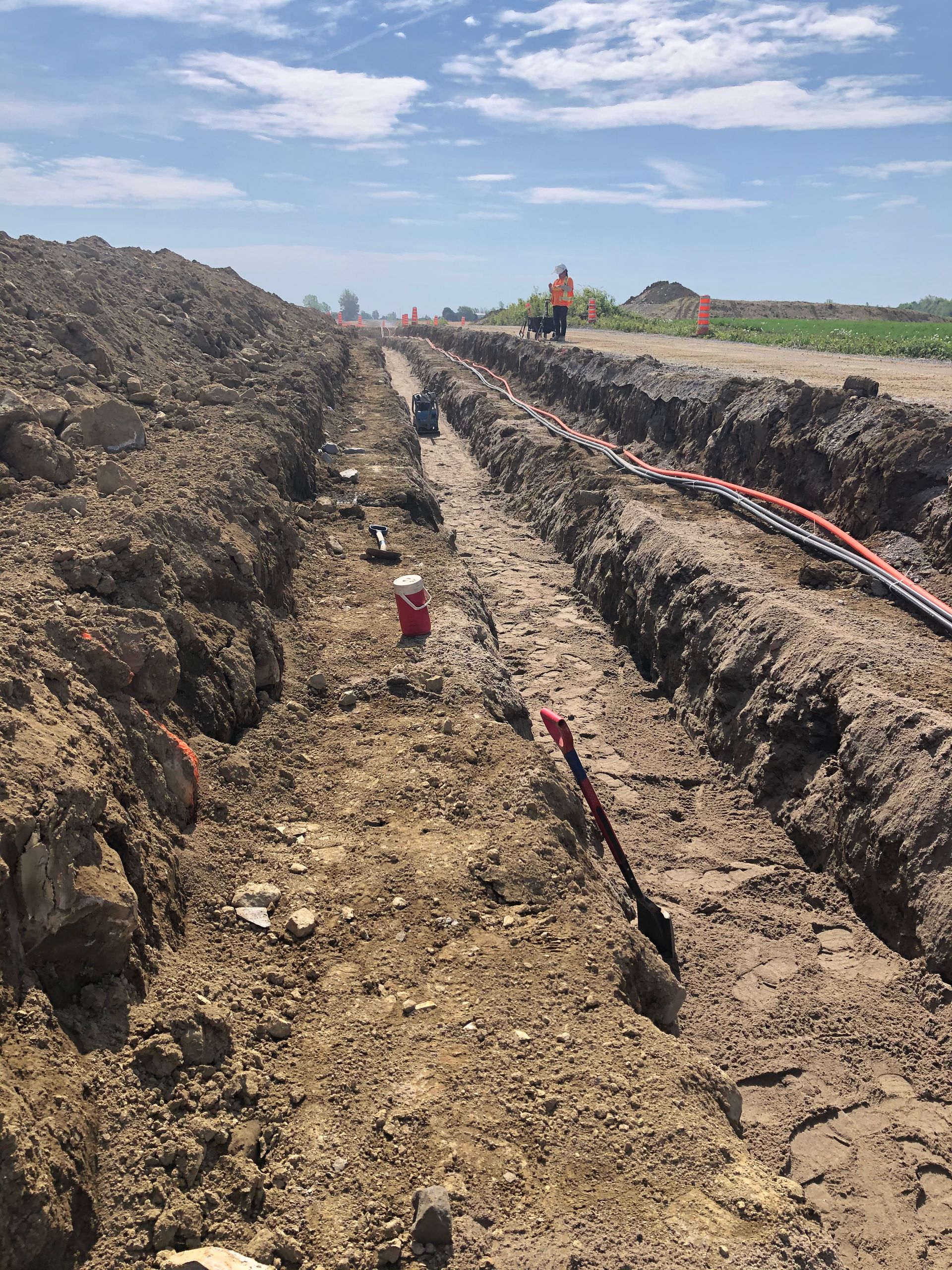 Une tranchée est creusée dans la terre à côté d'une route.