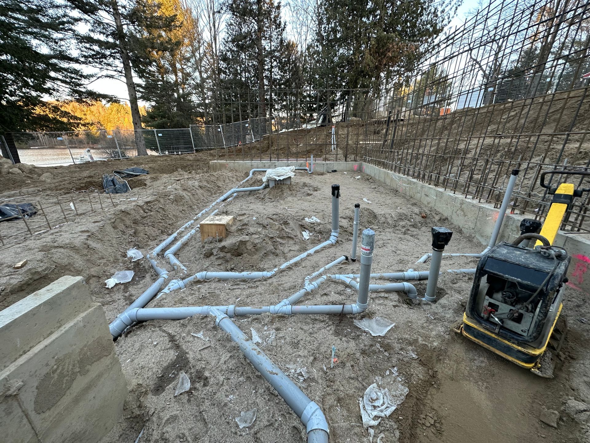 Un tas de tuyaux sont posés dans la terre sur un chantier de construction.