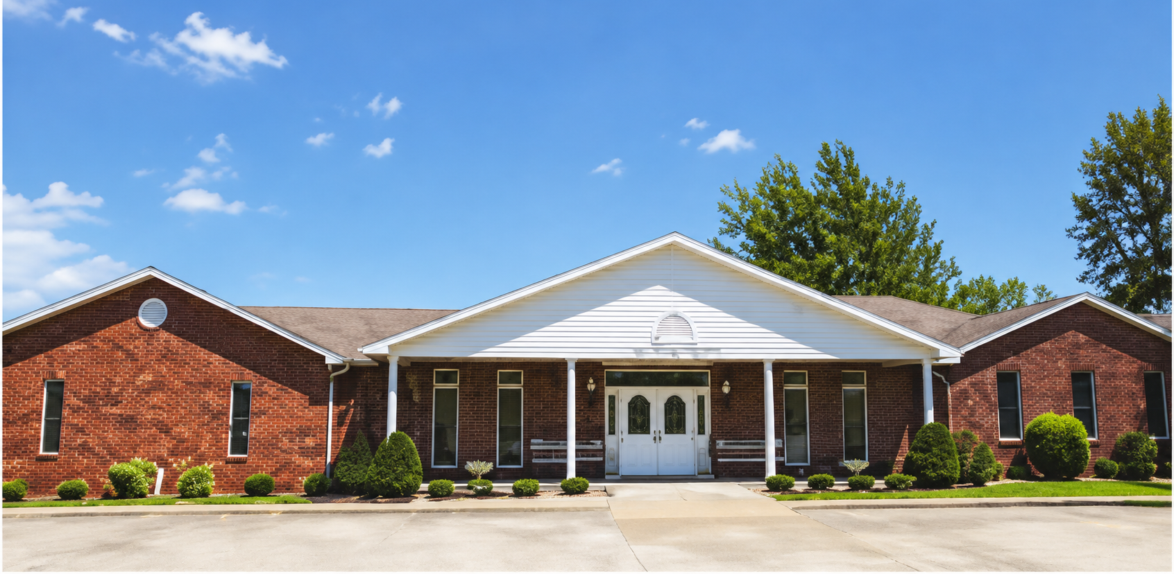 Brick office building with white columns and blue sky in front