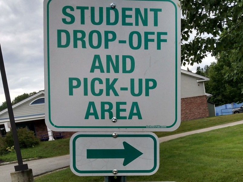 Student drop-off and pick-up area sign with a right arrow on a roadside.