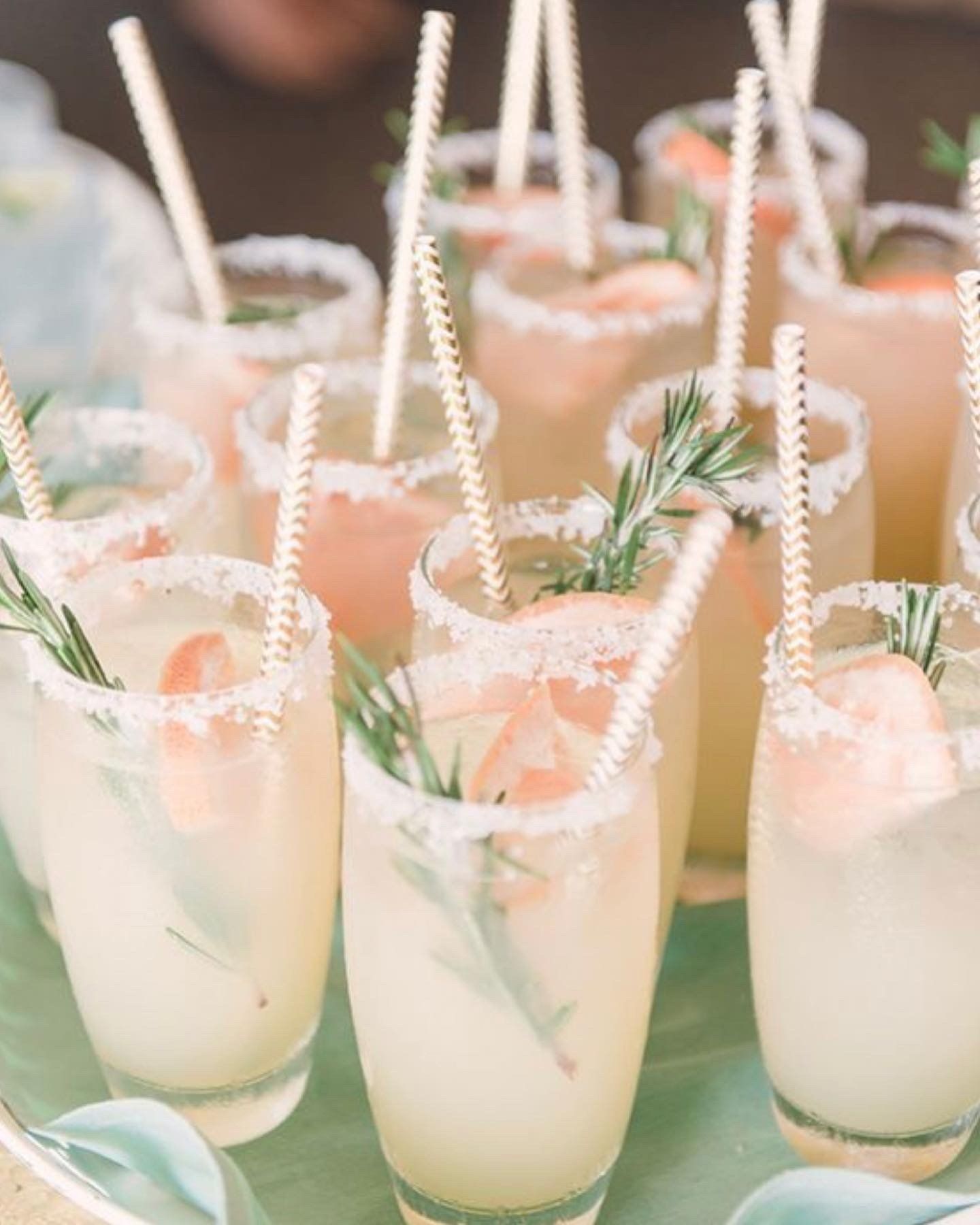 A tray of drinks with straws in them on a table.