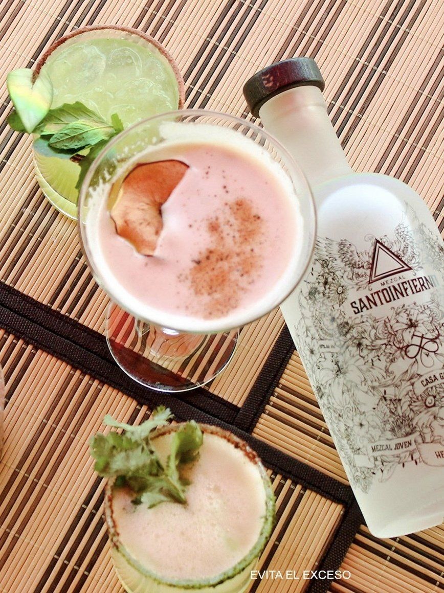 A bottle of alcohol is next to a glass of alcohol