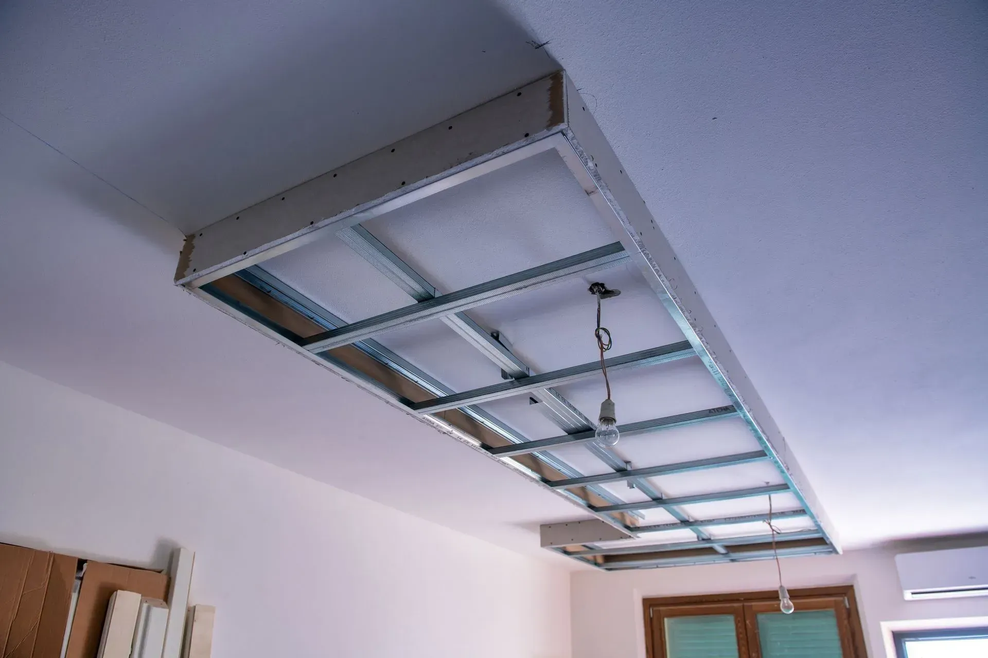Ceiling opening with exposed metal framing for a recessed light fixture under construction