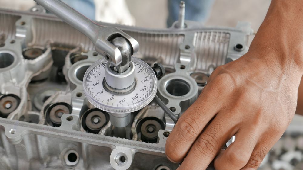 Person using angle torque wrench on engine cylinder head — P.K. Head Servicing & Reconditioning in Shellharbour, NSW