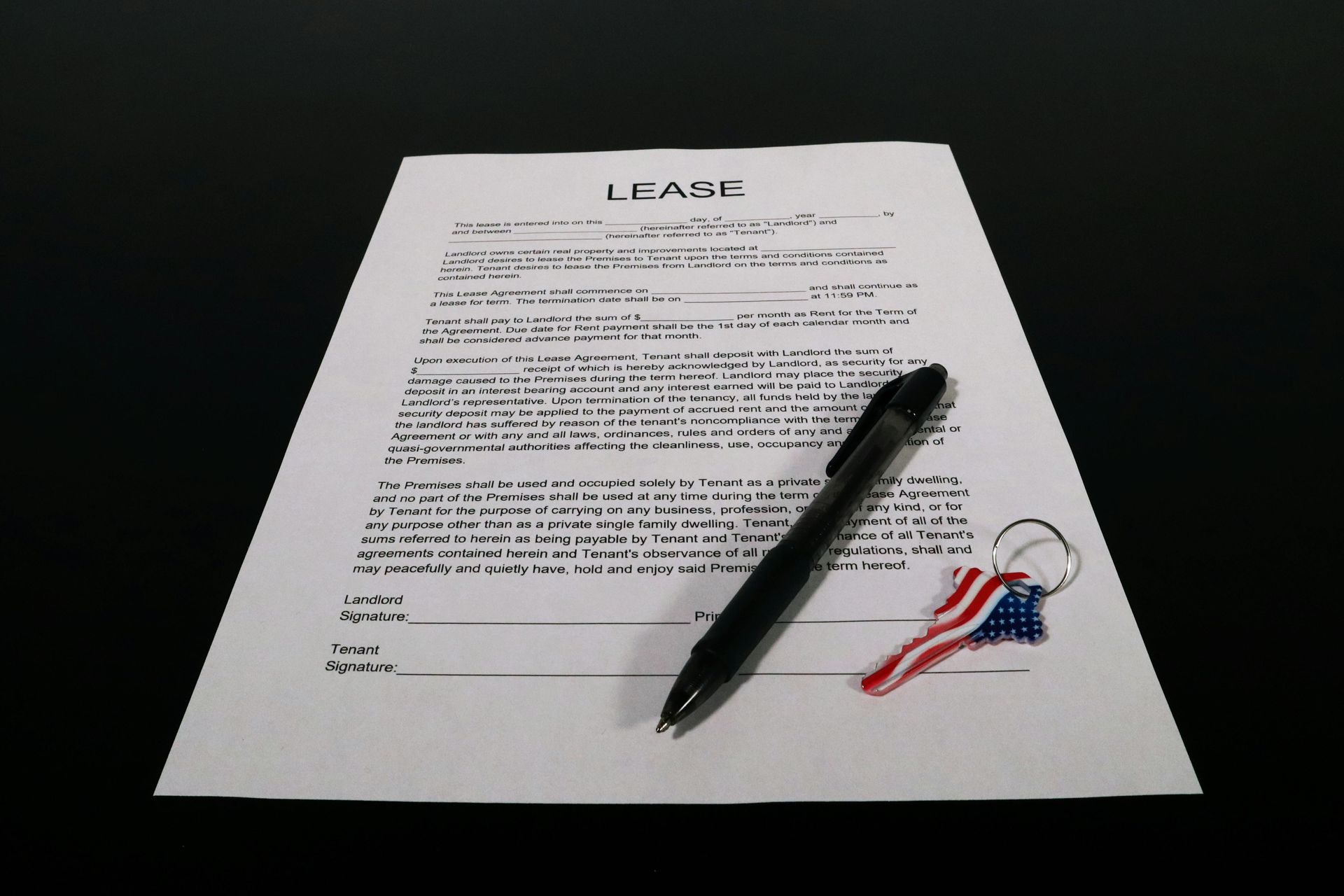 Rentals lease contract with a pen and key on top.
