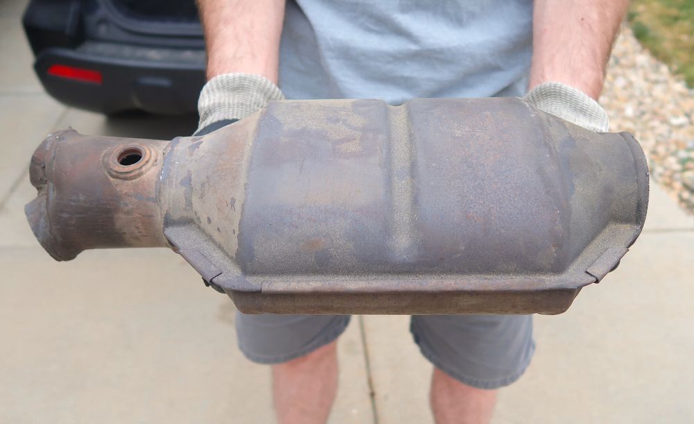 Person Holding a Catalytic Converter — Independent Scrap Metal Pty Ltd in Grafton, NSW