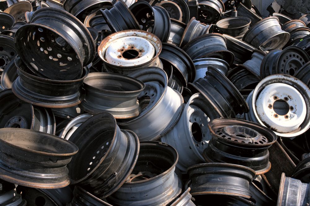 Pile of Used Black and White Car Rims at a Scrap Yard — Independent Scrap Metal Pty Ltd in Lismore, NSW