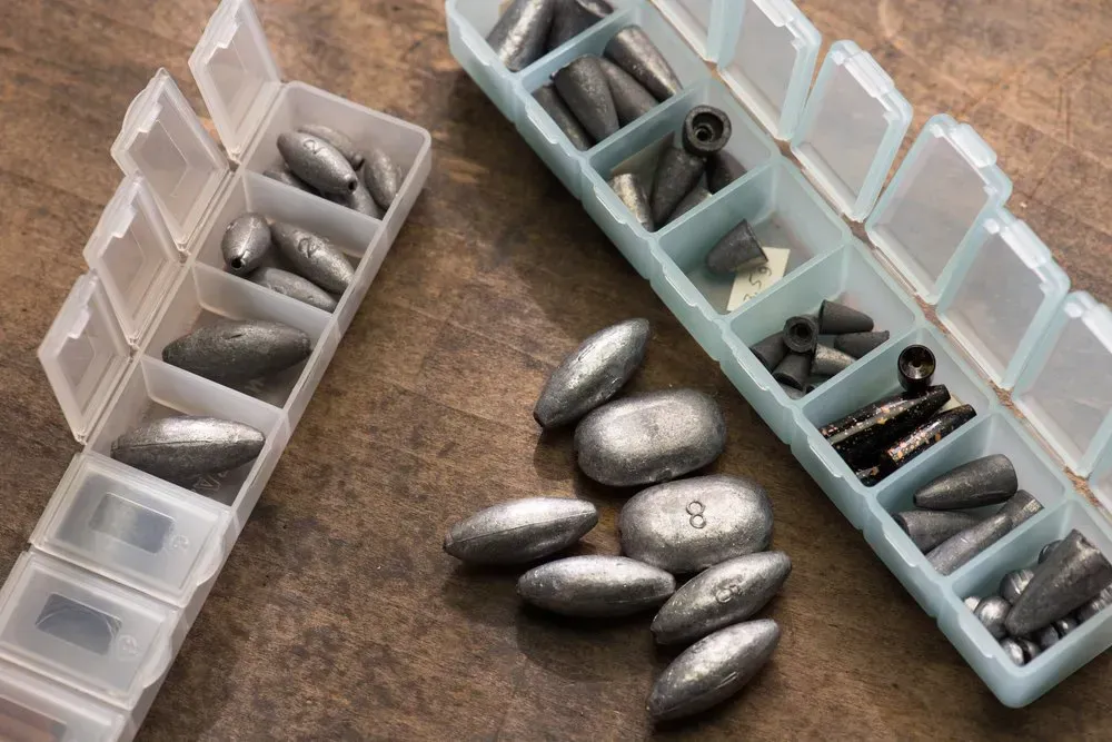 Fishing Weights Organized in Plastic Containers on a Wooden Surface — Independent Scrap Metal Pty Ltd in South Lismore, NSW