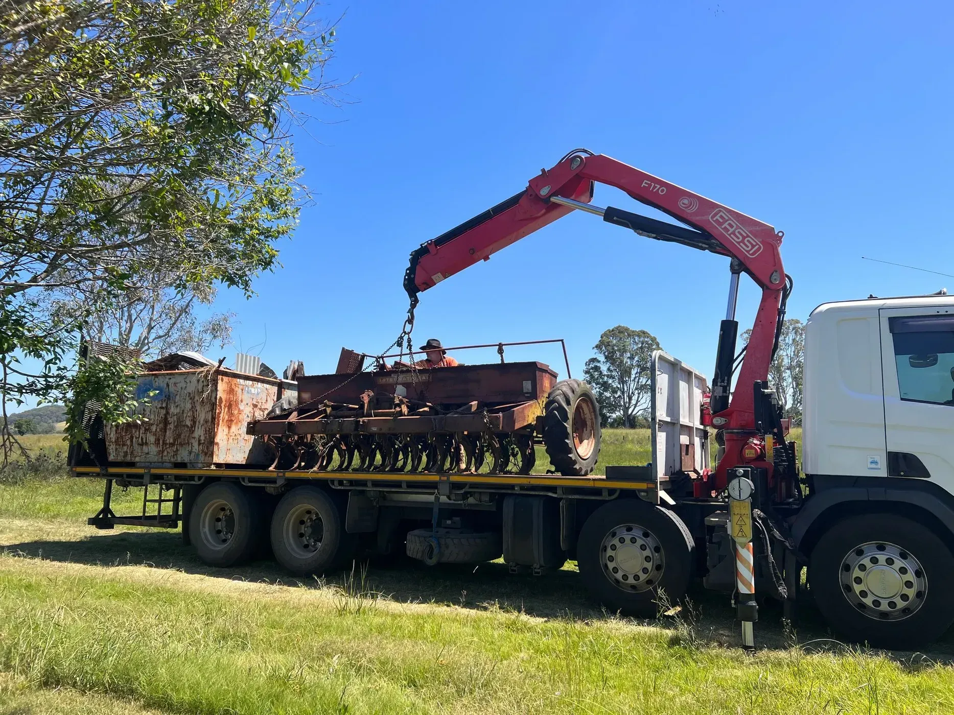 A Red Crane Loading a Rusty Farm Implement — Independent Scrap Metal Pty Ltd in Lismore, NSW