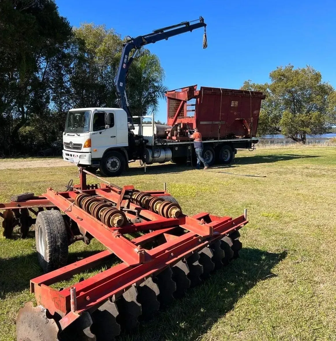 Truck With Crane Loading a Red Agricultural Bin — Independent Scrap Metal Pty Ltd in Mullumbimby, NSW