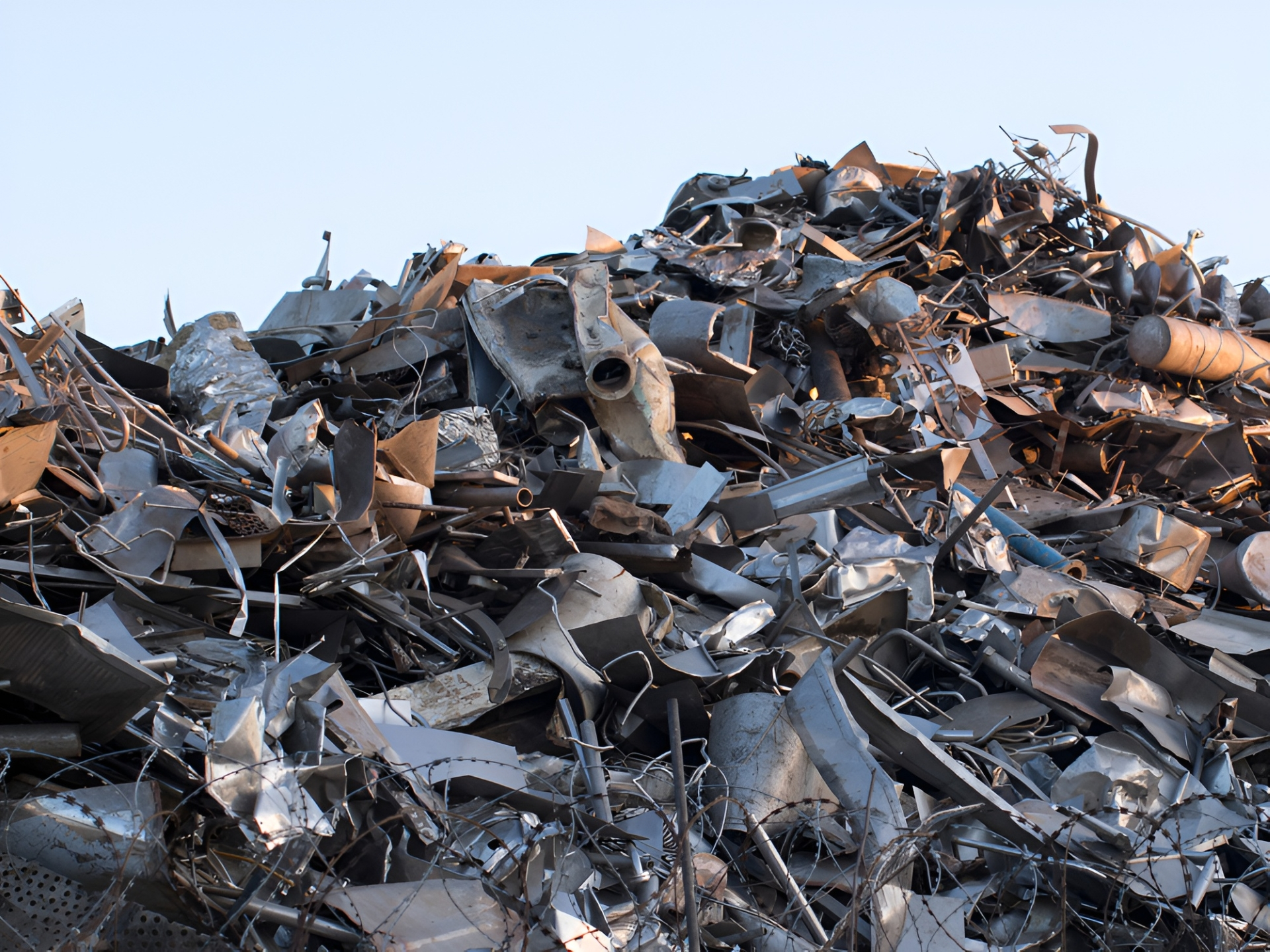 Pile of Scrap Metal, Including Car Parts, Against a Pale Blue Sky — Independent Scrap Metal Pty Ltd in Grafton, NSW