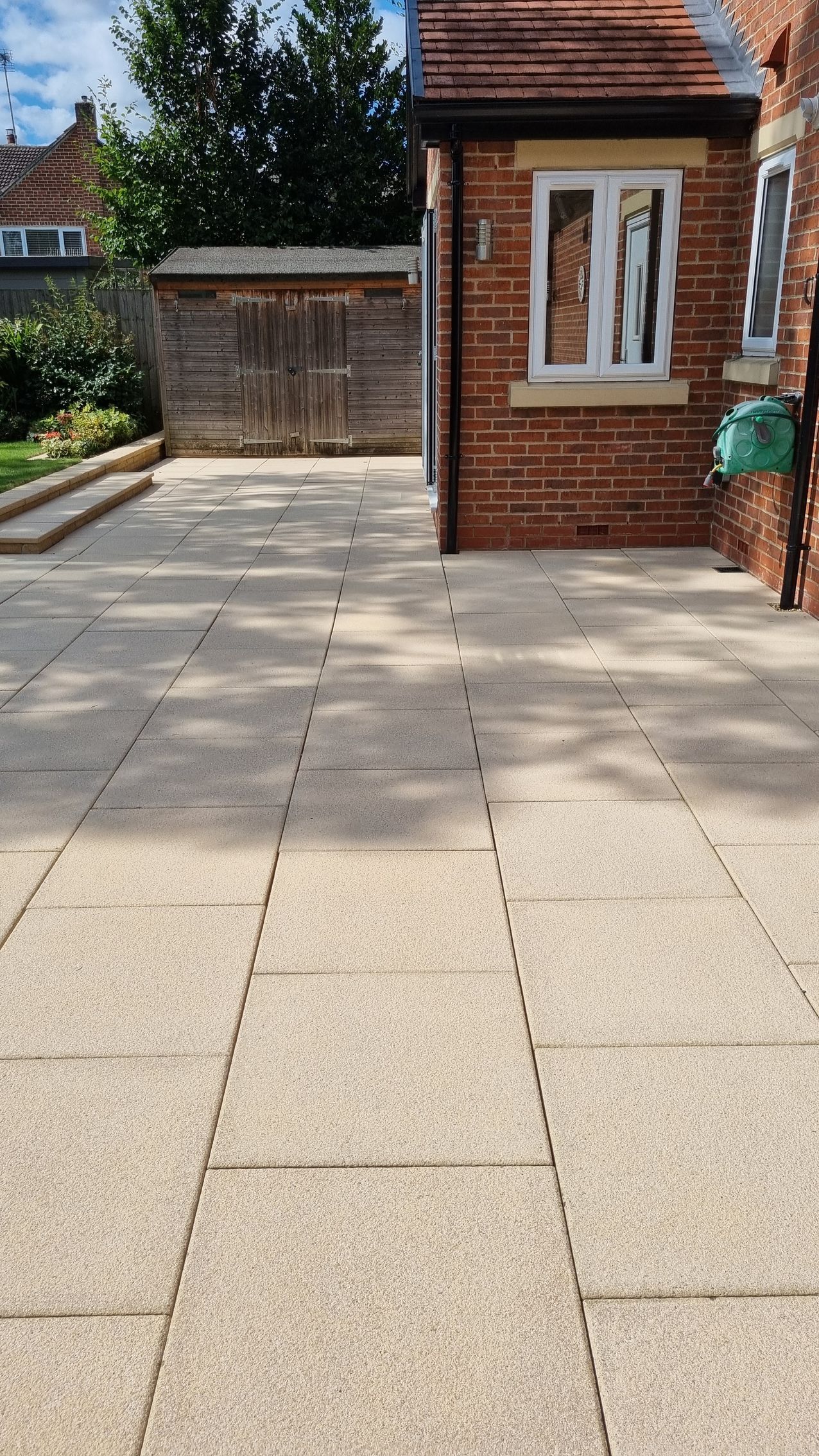 Concrete slab patio that is dirty and covered in algae before being pressure washed and chemically treated.