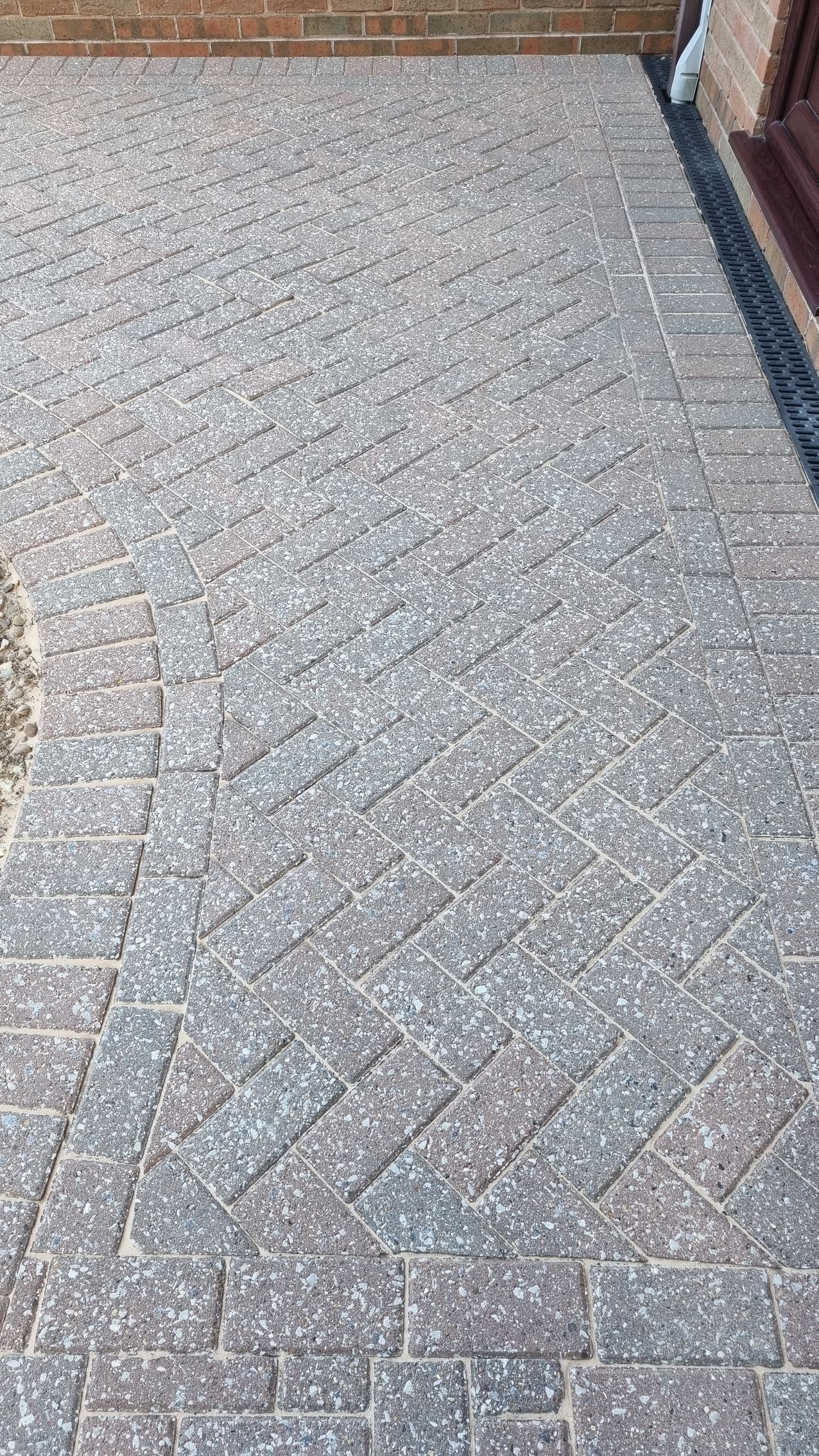 An area of a block paved driveway with moss growing on it, before being pressured washed.