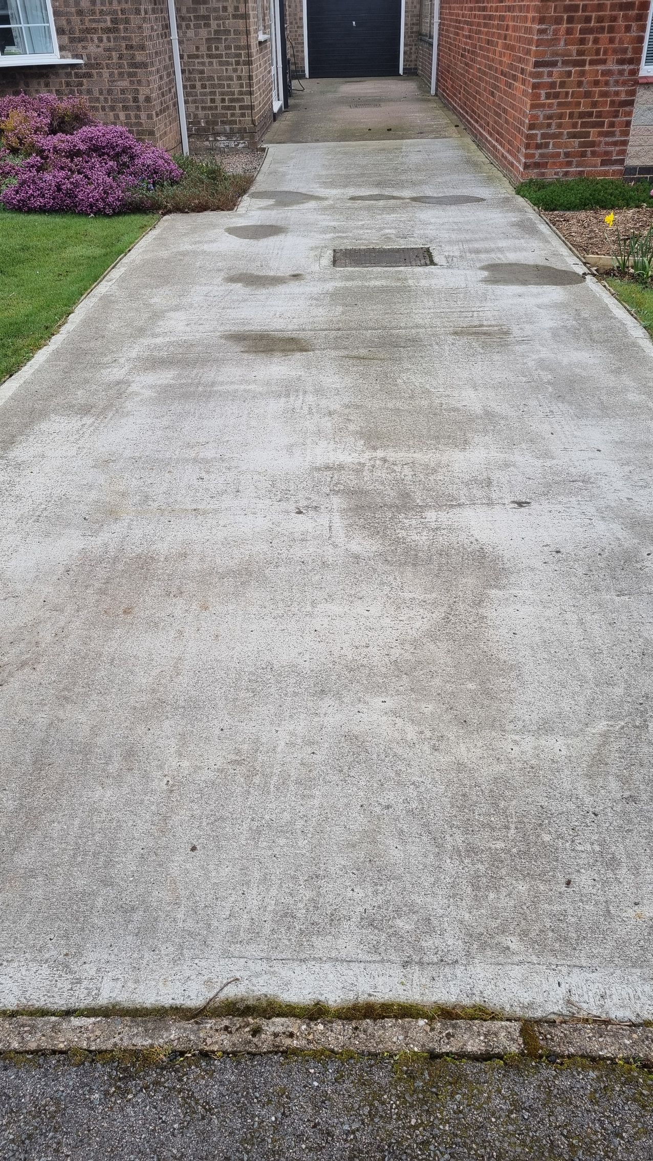 A concrete driveway before a professional driveway clean.
