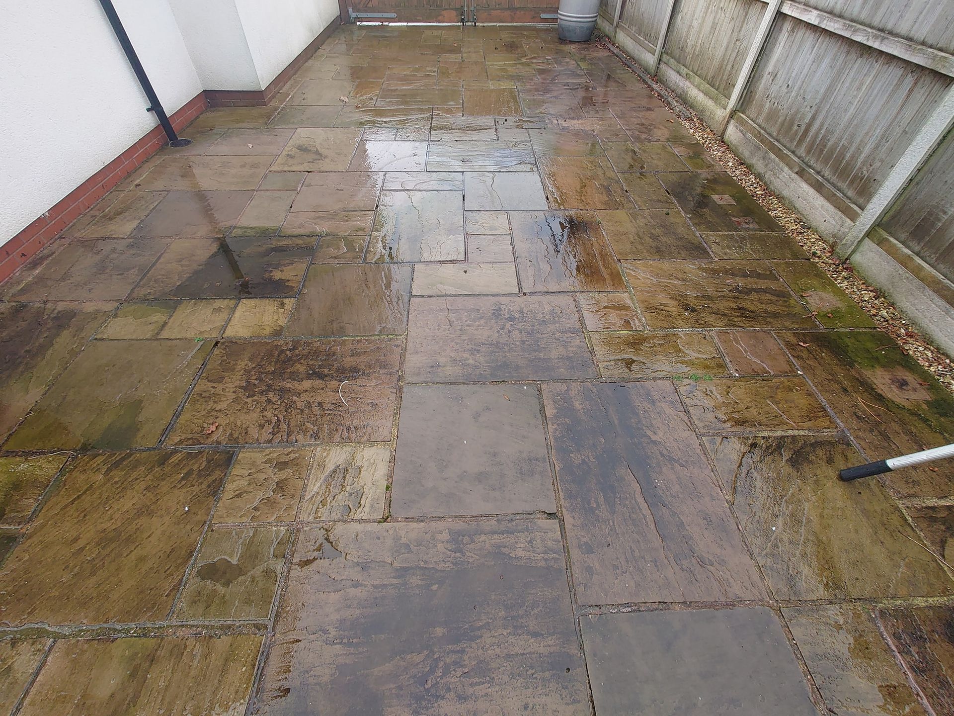 Concrete slab patio that is clean and bright after being pressure washed and chemically treated.