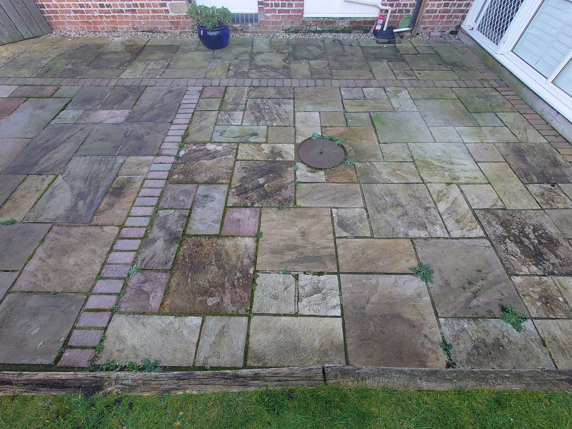 Indian Sandstone patio that is dull and dirty before being pressure washed.